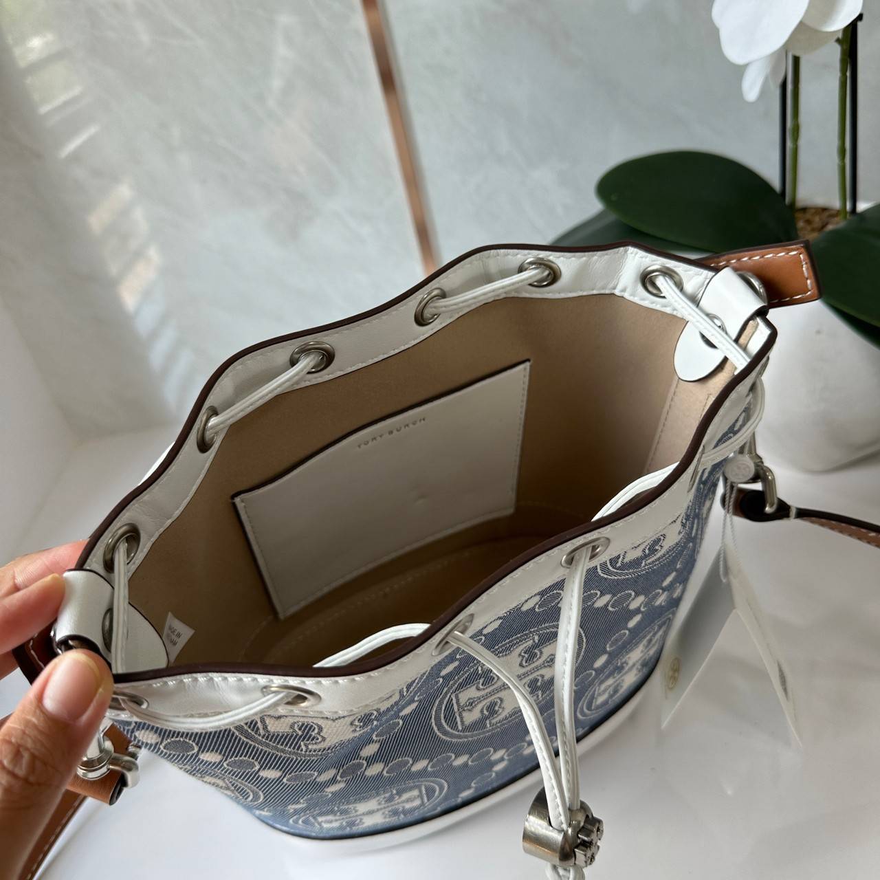 TORY BURCH T Monogram Denim Bucket Bag MEDIUM คอลเลคชั่นใหม่ รูปแบบคลาสสิค พกพาความหรูหราไปได้ทุกที่ด้วยกระเป๋าทรง Bucket ขนาดกลางและปิดด้วยเชือกรูดพร้อมโลโก้แวววาว วัสดุผ้าเดนิมแจ็คการ์ด ตัดขอบหนังแท้