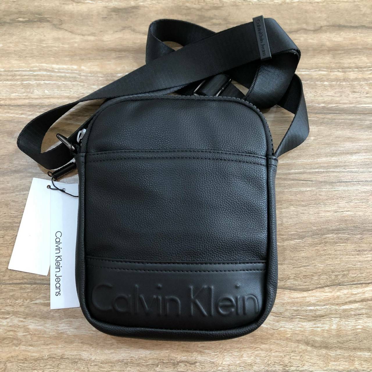 CALVIN KLEIN JEANS CROSSBODY BAG กระเป๋าสะพายจาก Calvin Klein Jeans วัสดุหนังpuคุณภาพดีเนื้อนิ่ม น้ำหนักเบา กันน้ำ ด้านหน้ามีปั้มโลโก้ เปิดปิดด้วยซิปสะดวกใช้ หัวซิปแบรนด์ ด้านหน้ามีช่องโล่งไว้ใส่ของหยิบใช่สะดวก ภายในมีโลโก้เเละช่องโล่ง ใส่กระเป๋าสตางค์ใบย