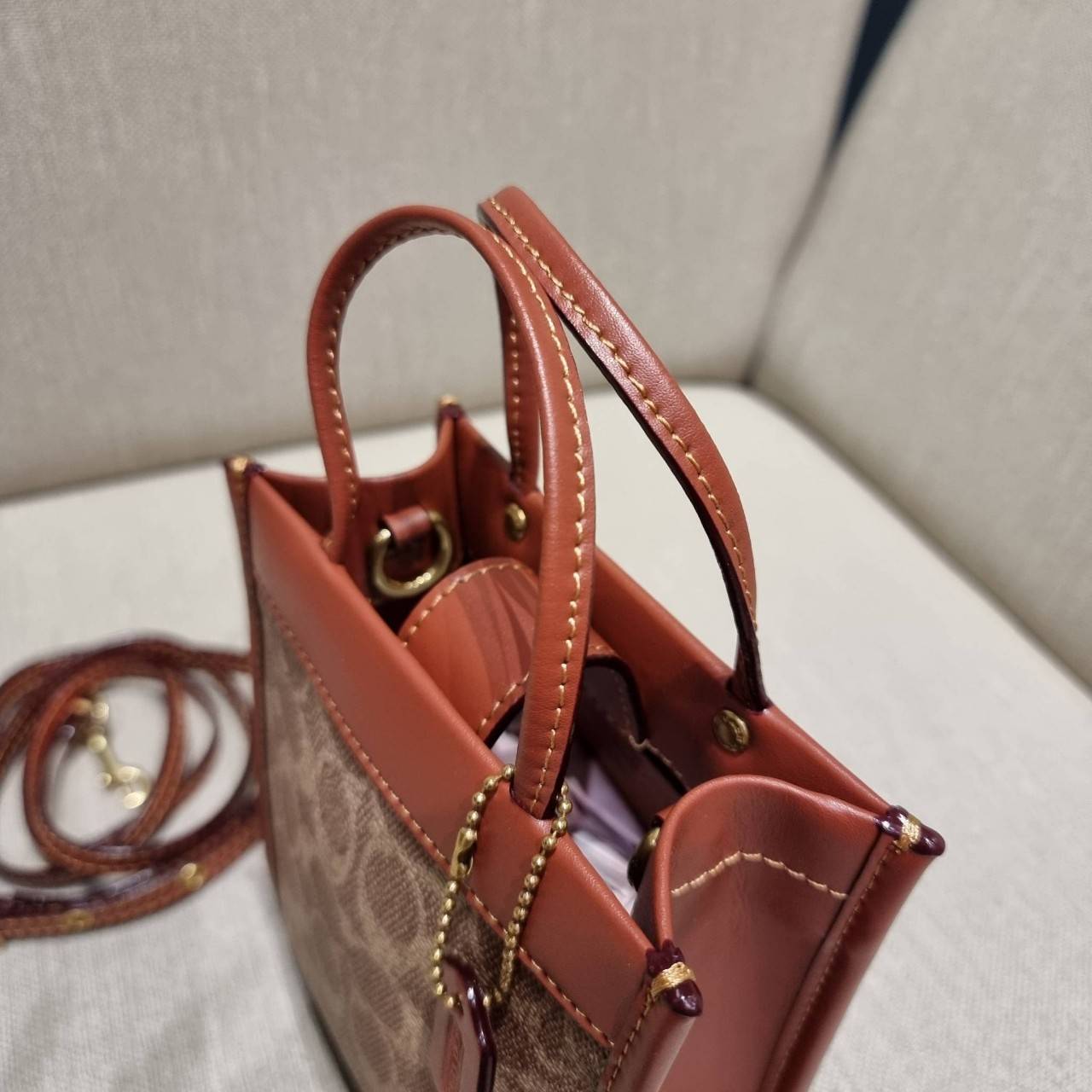 COACH C5277 MINI CASHIN TOTE IN SIGNATURE CANVAS กระป๋าสะพายข้างไซส์มินิ ไอเท็มหายาก!! ที่น่ารักที่สุด!! น่าใช้ไม่อยากวาง!! ยกให้น้องสาวใบนี้จริงๆ ดีไซน์รูปทรงโท้ทคลาสสิค วัสดุหนังแคนวาสสลับหนังแท้ มีหูจับในตัวและสายสะพายข้าง ปากกระเป๋ามีสายหนังแถบแม่เหล็