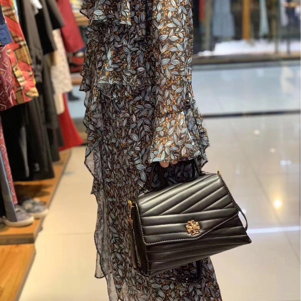 TORY BURCH Kira Chevron Top-handle Satchel กระเป๋าหนังแกะ สัมผัสนุ่มควบคู่กับดีไซน์อันเป็นเอกลักษณ์ กระเป๋าถือทรงสวยที่มีดีไซน์อันเป็นเอกลักษณ์ไม่เหมือนกับที่ไหน ด้วยการตัดเย็บหนังแกะแสนนุ่มแบบลายบุสองชั้น เพิ่มมูลค่าด้วยสายสะพายที่ทำจากโลหะสีทอง อีกทั้งย