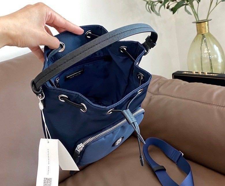 Tory Burch Virginia Nylon Bucket Bag / Tory Burch logo-plaque bucket bag กระเป๋าสะพายทรงบัคเก็ต เปิด-ปิดหนังรูดปากกระเป๋า มีหูหิ้วในตัว คล้องแขนเก๋ๆ ภายในเป็นช่องโล่ง มีช่องย่อย ใส่ของสำคัญจุกจิกได้ มีสายครอส จะสะพายไปไหนก็ได้ทุกโอกาส สวยเลิศทุกสี พร้อมส่