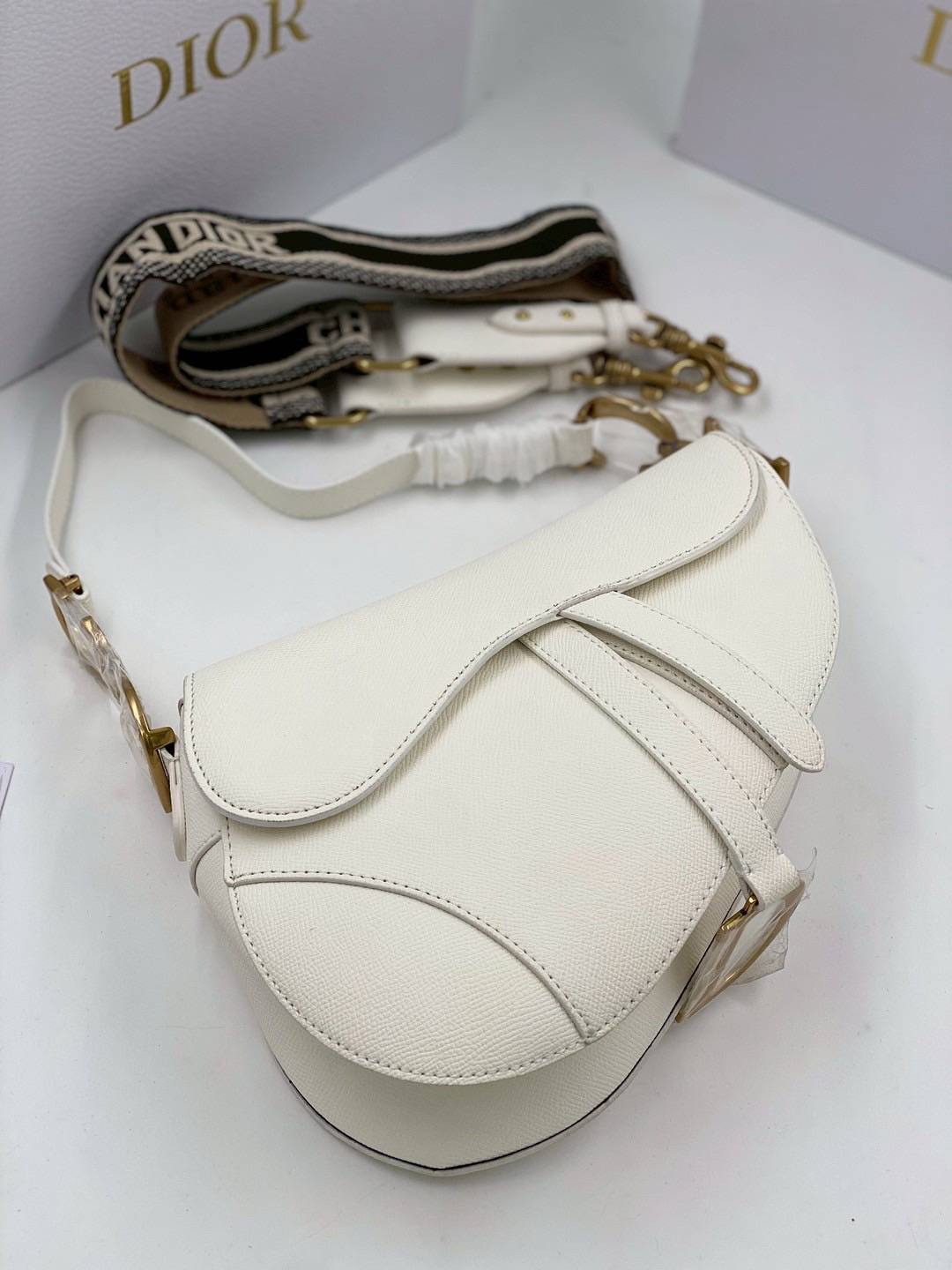 ORI หนังแท้ | DIOR Saddle Bag with Strap Grained Leather กระเป๋าถือ/สะพายทรงอานม้า รุ่นยอดนิยมที่มีเอกลักษณ์สวยงามเหนือกาลเวลา ลูกเล่นห้อยด้วยตัวอักษร D ตรงหูหิ้วมีกิมมิค CD สวยหรูดูแพง