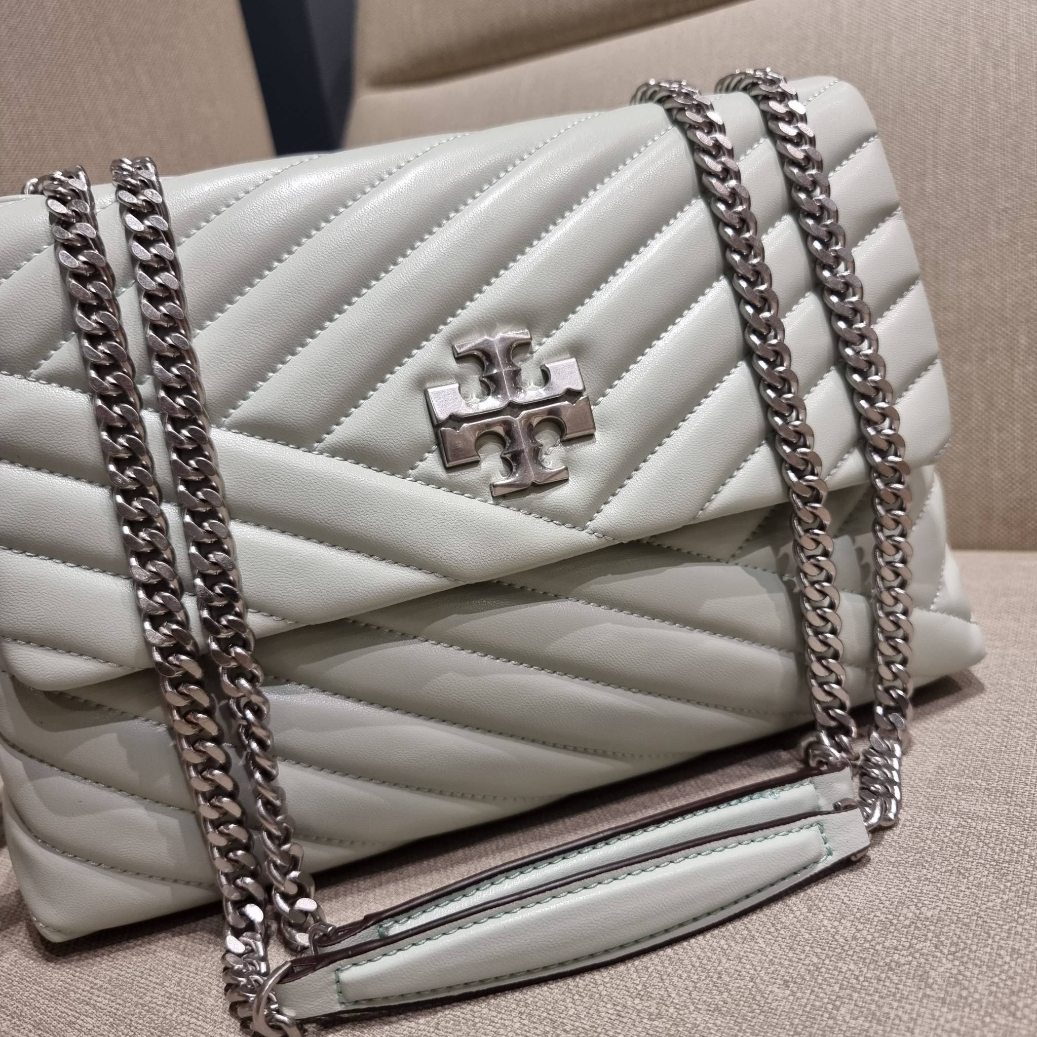 TORY BURCH KIRA CHEVRON CONVERTIBLE SHOULDER BAG กระเป๋าสะพายรุ่นยอดฮิต ไซส์ใหญ่จัดเต็มให้เน้นๆ ใช้ยังไงก็ดูหรู ดีไซน์เฉพาะตัว วัสดุหนังแกะ สัมผัสนิ่ม เปิด-ปิดด้วยกระดุมแม่เหล็ก ภายในเป็นช่องโล่ง แบ่งสัดส่วนไว้ดีมากๆ ใส่กระเป๋าสตางค์ มือถือ เครื่องสำอางค์