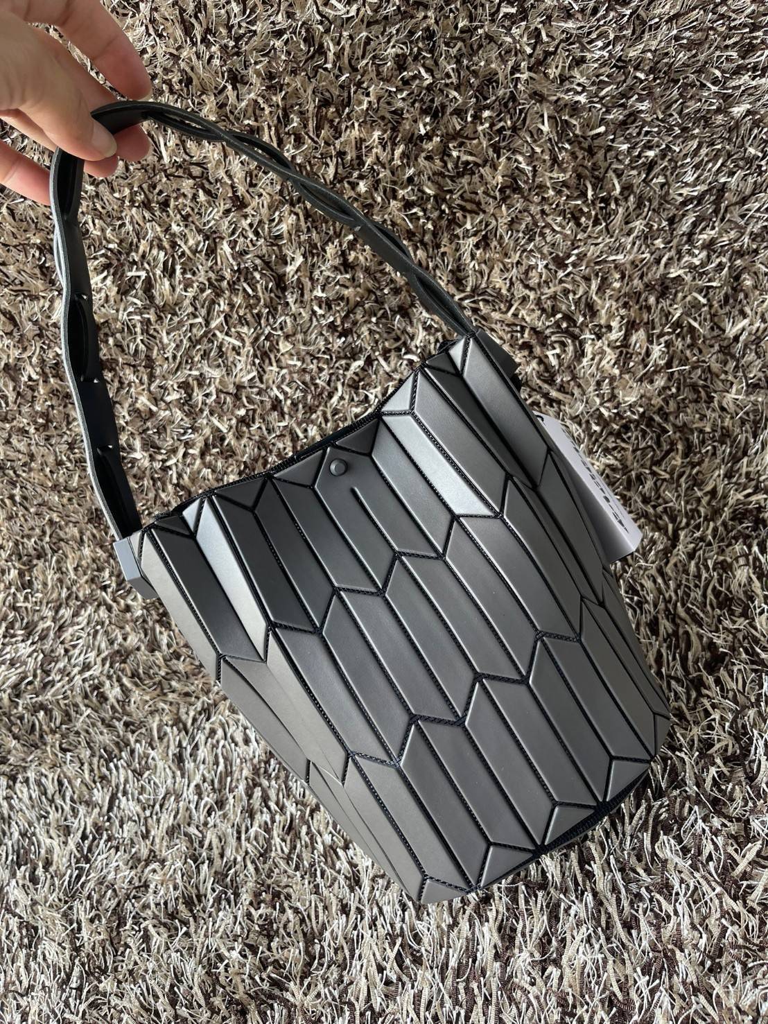 Small : BAO BAO ISSEY MIYAKE SMALL BUCKET เป็นกระเป๋าบัคเก็ตขนาดเล็กสามารถใช้ใส่กระเป๋าสตางค์และโทรศัพท์มือถือได้ ซีรีย์ใหม่นี้มีจุดเด่นที่แผ่นรูปทรงสี่เหลี่ยมด้านขนานในแนวตั้ง เกิดเป็นรูปทรงสามมิติซึ่งแตกต่างไปจากรูปทรงที่เกิดขึ้นจากแผ่นสามเหลี่ยม หูหิ้ว