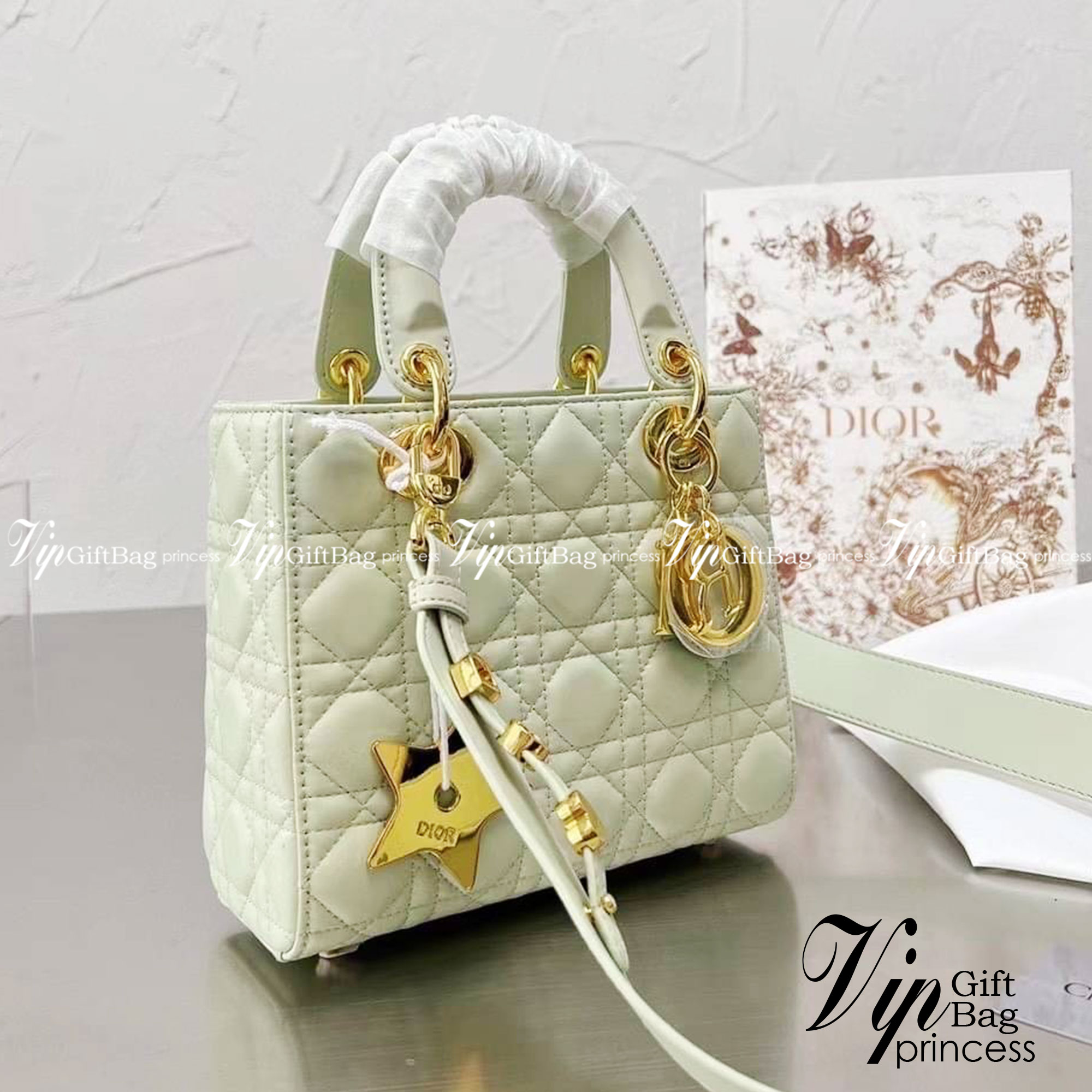 DIOR Lady / Small Lady Dior Bag Cannage Lambskin กระเป๋าสุดไอคอนิก รูปทรงสีเหลียม ขนาดกระทัดรัด ตั้งอยู่ทรง ฐานกระเป๋าแข็งแรง มีหมุดรองฐาน ดีไซน์เอกลักษณ์เฉพาะตัว ด้านหน้าตกแต่งด้วยตัวอักษร D.I.R ห้อยเป็นพวงกุญแจ จะถือหรือสะพายไหล่ก็ดูดีมากๆ ค่ะ