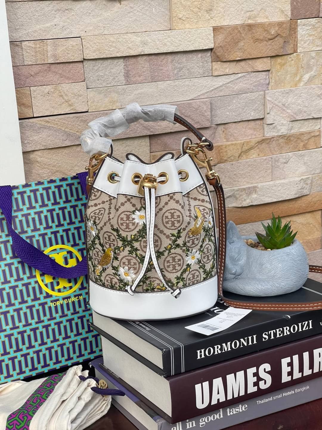 ของแท้ 💯% 】shop Mini : TORY BURCH T MONOGRAM JACQUARD EMBROIDERED MINI BUCKET BAG รุ่นใหม่ล่าสุดจาก TORY BURCH ครั้งแรกกับโมโนแกรม ที่ได้รับแรงบันดาลใจมาจากโลโก้สุดคลาสสิก กลับมาอีกครั้งในรูปแบบของ ลวดลาย T Monogram