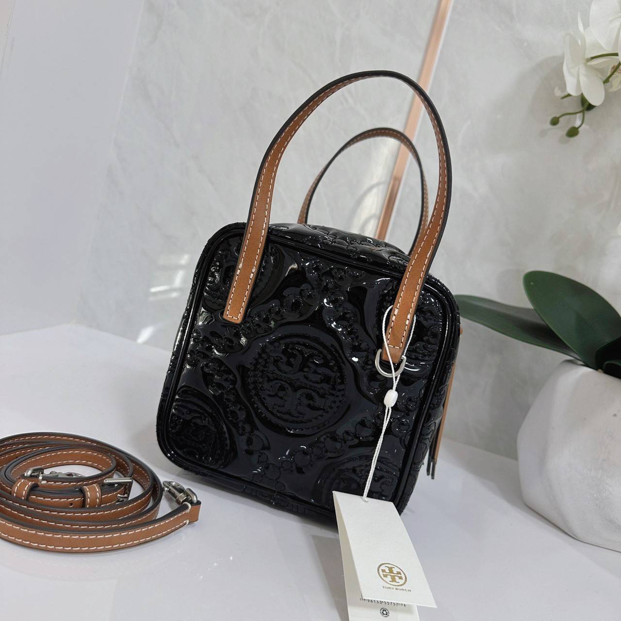 Tory Burch T Monogram Embroidered Patent Cube คอลเลคชั่นใหม่ รุ่นลิมิเต็ดรูปทรงใหม่ T Monogram สุดcube วัสดุหนังแท้ เปิด-ปิดด้วยซิป ภายในกว้าง มีช่องแยก 1 ช่อง สามารถใส่โทรศัพท์มือถือได้ทุกรุ่น สามารถถือหิ้วหรือสะพายได้ สายสามารถถอดและปรับระดับได้คะ