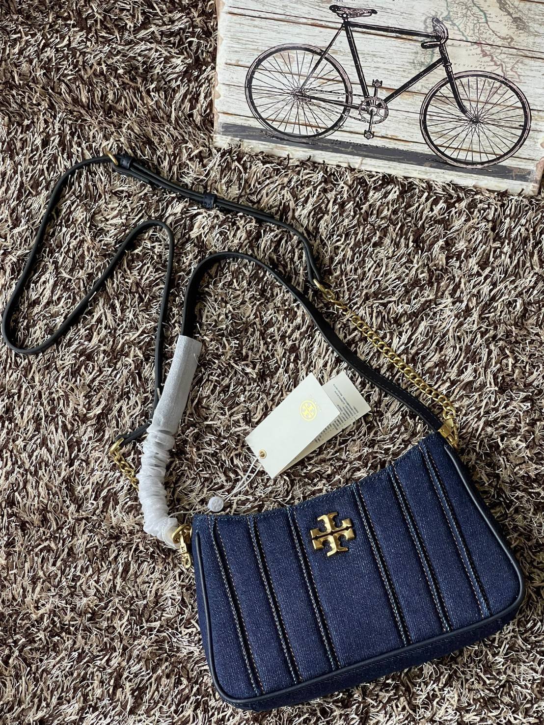 Tory burch Kira logo-plaque crossbody bag กระเป๋า Kira ของ Tory Burch เป็นส่วนหนึ่งของคอลเล็กชั่นที่โดดเด่น และมีหลายรุ่นด้วยกัน โดยมีป้ายโลโก้ Double T ของแบรนด์อยู่ตรงกลาง มีความเรียบง่ายแต่ยังคงความหรูหราโดดเด่นด้วยวัสดุบุผิว ป้ายโลโก้สีทอง สายสะพายโซ่