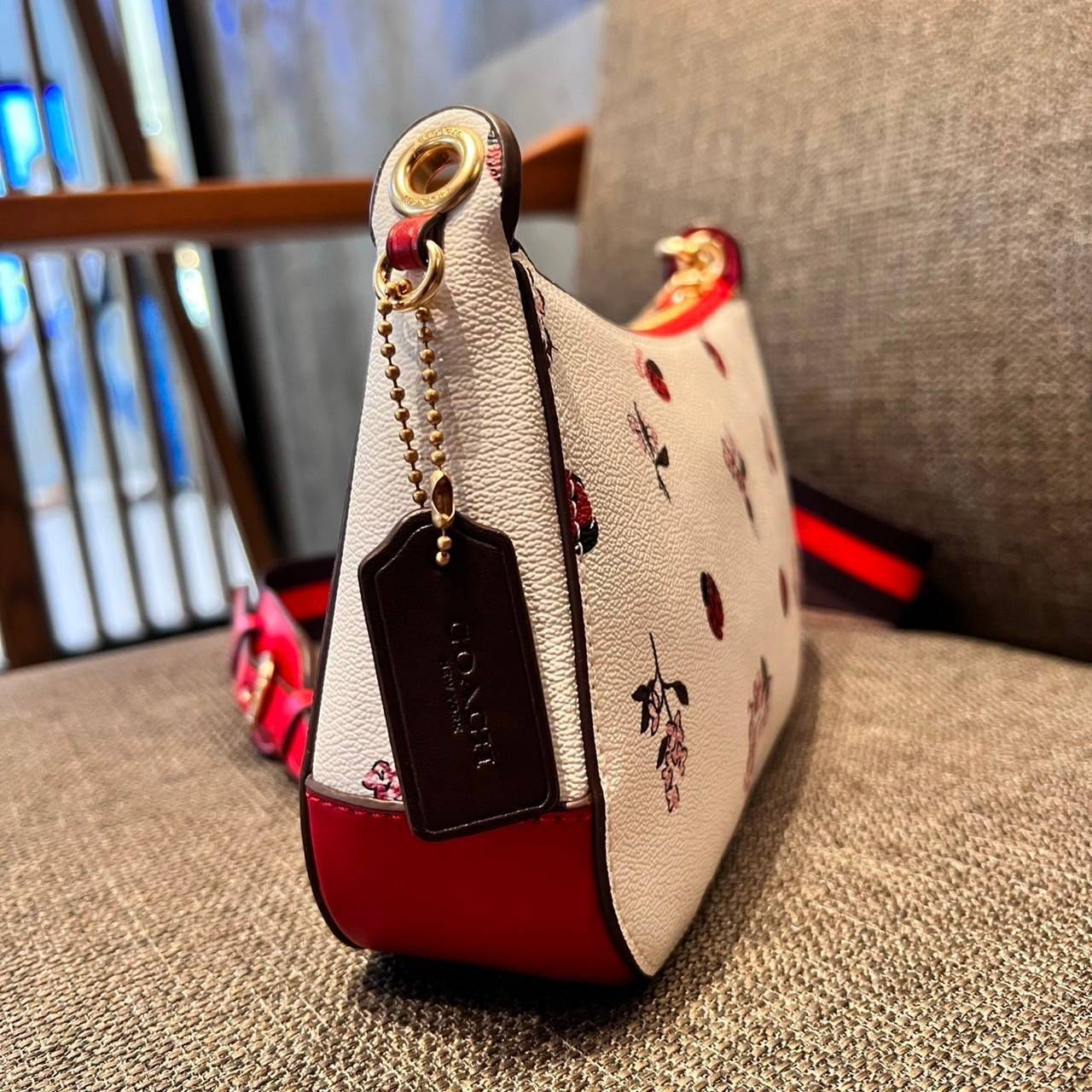 COACH C7973 JES BAGUETTE WITH LADYBUG FLORAL PRINT คอลเลคชั่นใหม่ล่าสุด พร้อมเสิร์ฟความสวยถึงบ้านเช่นเคย!! กระเป๋าสะพายทรงบาแกตต์ ดีไซน์ย้อนยุค ที่แอบแฝงความเรียบหรูดูแพงอยู่ในตัว โดดเด่นด้วยสายสะพายเส้นใหญ่ โทนสีคอนทราส ทำให้ไอเท็มนี้ดูมีลูกเล่นมากขึ้น ว