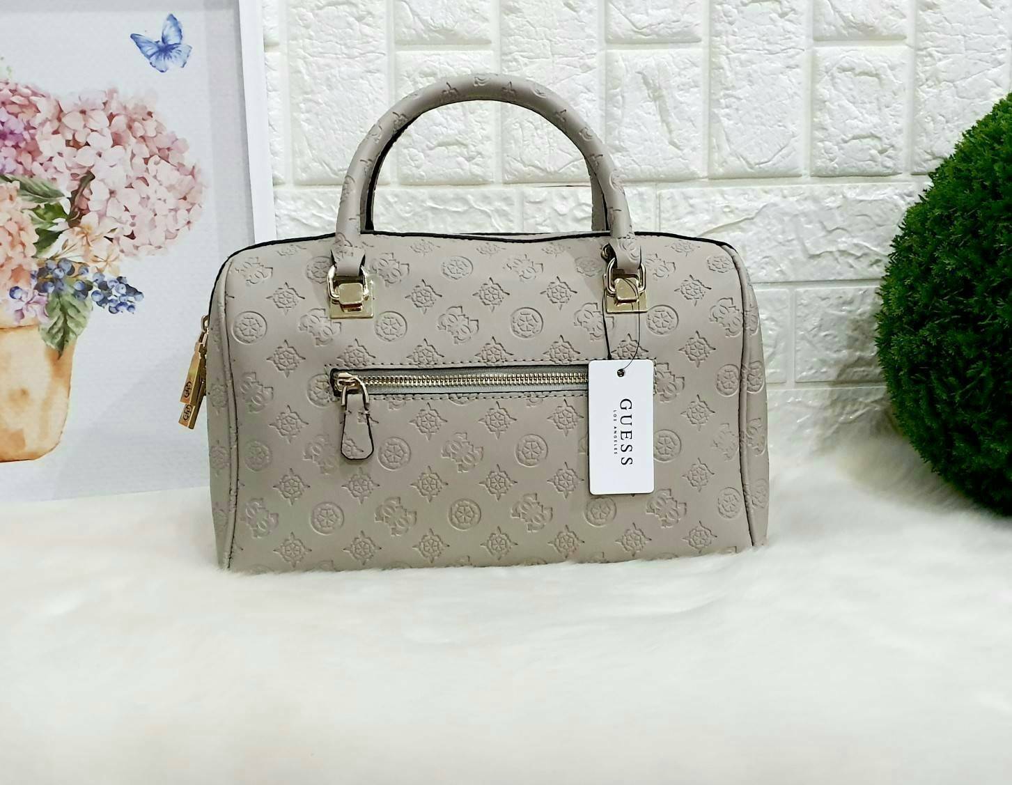 Guess Peony Classic Box Satchel คอลเลคชั่นใหม่สวยหรูจาก Guess กระเป๋าสะพายหนังนิ่มปั๊มแบรนด์รอบใบ ขนาดกำลังดี ฐานกระเป๋ามีหมุดรองฐานกันรอย หัวซิปปั๊มแบรนด์ ภายในกว้างจุของได้เยอะ มาพร้อมสายปรับและถอดออกได้ พร้อมส่ง 4 สี สวยทุกสี พลาดไม่ได้กับสาวยุคใหม่เลย