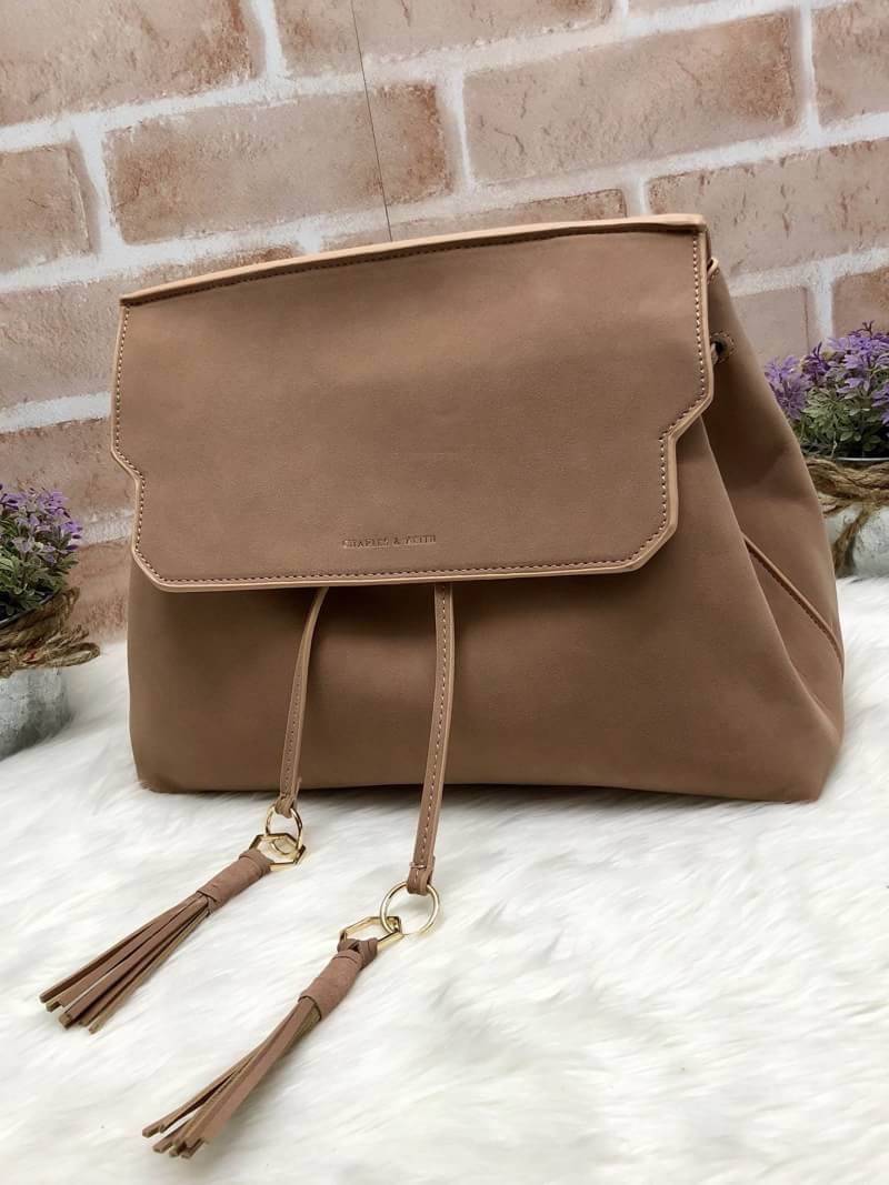 CHARLES & KEITH TASSEL DETAIL SLING BAG กระเป๋าสะพายทรงสวย ที่ฝาพับด้านหน้าแต่งหนังตัดกับหนังกลับสวยงาม สะพายได้ทั้งแบบเป้ และสะพายข้างก็เก๋ไปอีกแบบ มีโซ่เหล็กห่วงห้อยตุ้งติ้งน่ารัก จุของได้เยอะ พร้อมปั๊มโลโก้แบรนด์สีทองเด่น ภายในมีช่องแบ่งใหญ่ใส่ iPhone 