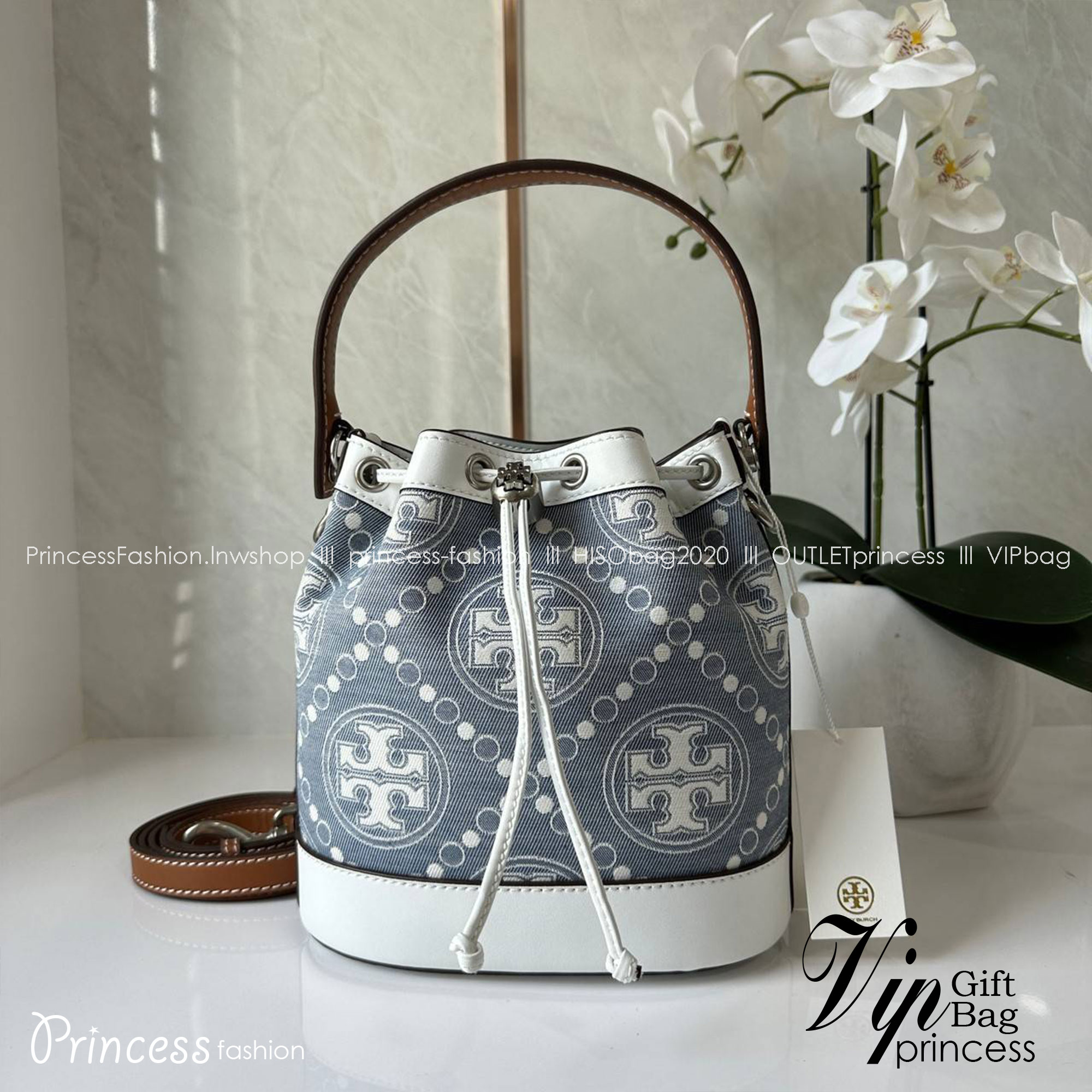 TORY BURCH T Monogram Denim Bucket Bag MEDIUM คอลเลคชั่นใหม่ รูปแบบคลาสสิค พกพาความหรูหราไปได้ทุกที่ด้วยกระเป๋าทรง Bucket ขนาดกลางและปิดด้วยเชือกรูดพร้อมโลโก้แวววาว วัสดุผ้าเดนิมแจ็คการ์ด ตัดขอบหนังแท้