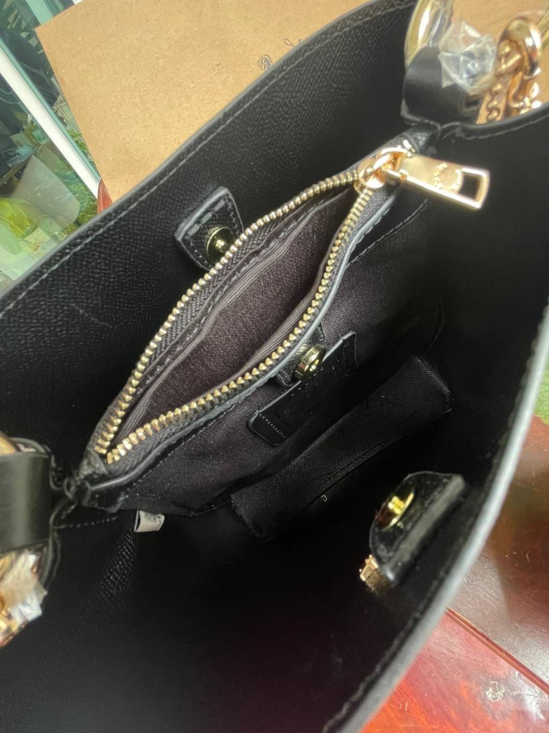 COACH SMALL TOWN BUCKET BAG IN SIGNATURE สำหรับสาวแฟชั่นที่ชอบรายละเอียดชิคๆ ดีไซน์สุดเก๋ แนะนำเลยสำหรับกระเป๋าทรงบักเก็ตใบนี้ เชื่อว่าสาว ๆ หลายคนชื่นชอบ เป็นไอเทมที่สามารถแมทช์ได้กับเสื้อหลากหลายสไตล์ บรรจุของได้เยอะโดยที่กระเป๋าไม่เสียทรง แบ่งช่องใช้งา