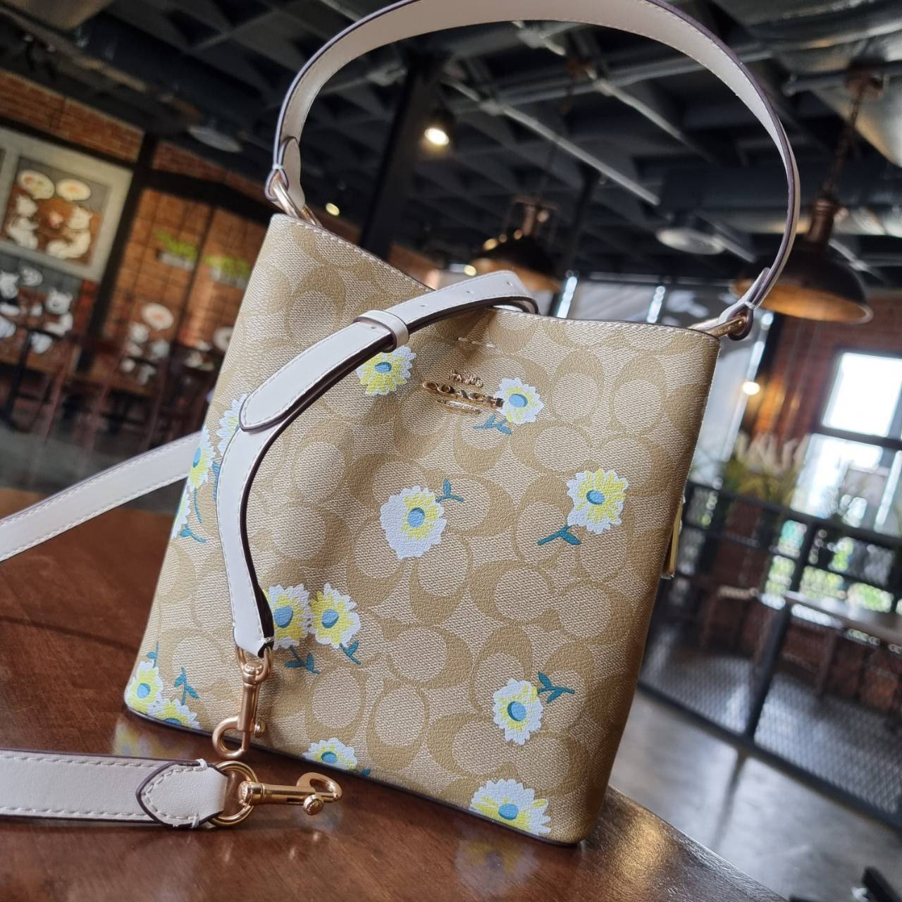OUTLET 】COACH C3411 SMALL TOWN BUCKET BAG IN SIGNATURE CANVAS WITH DAISY PRINT สวยสดใสมาให้ถึงบ้านจ้า!! กระเป๋าทรงบัคเก็ตยอดฮิต รอบนี้น่ารักมุ้งมิ้งไม่เลิก ดีไซน์ลายดอกเดซี่คละรอบใบ วัสดุหนังแคนวาสเคลือบลาย ปากกระเป๋าเปิด-ปิดด้วยกระดุมแม่เหล็ก 2ฝั่ง มีหูจ