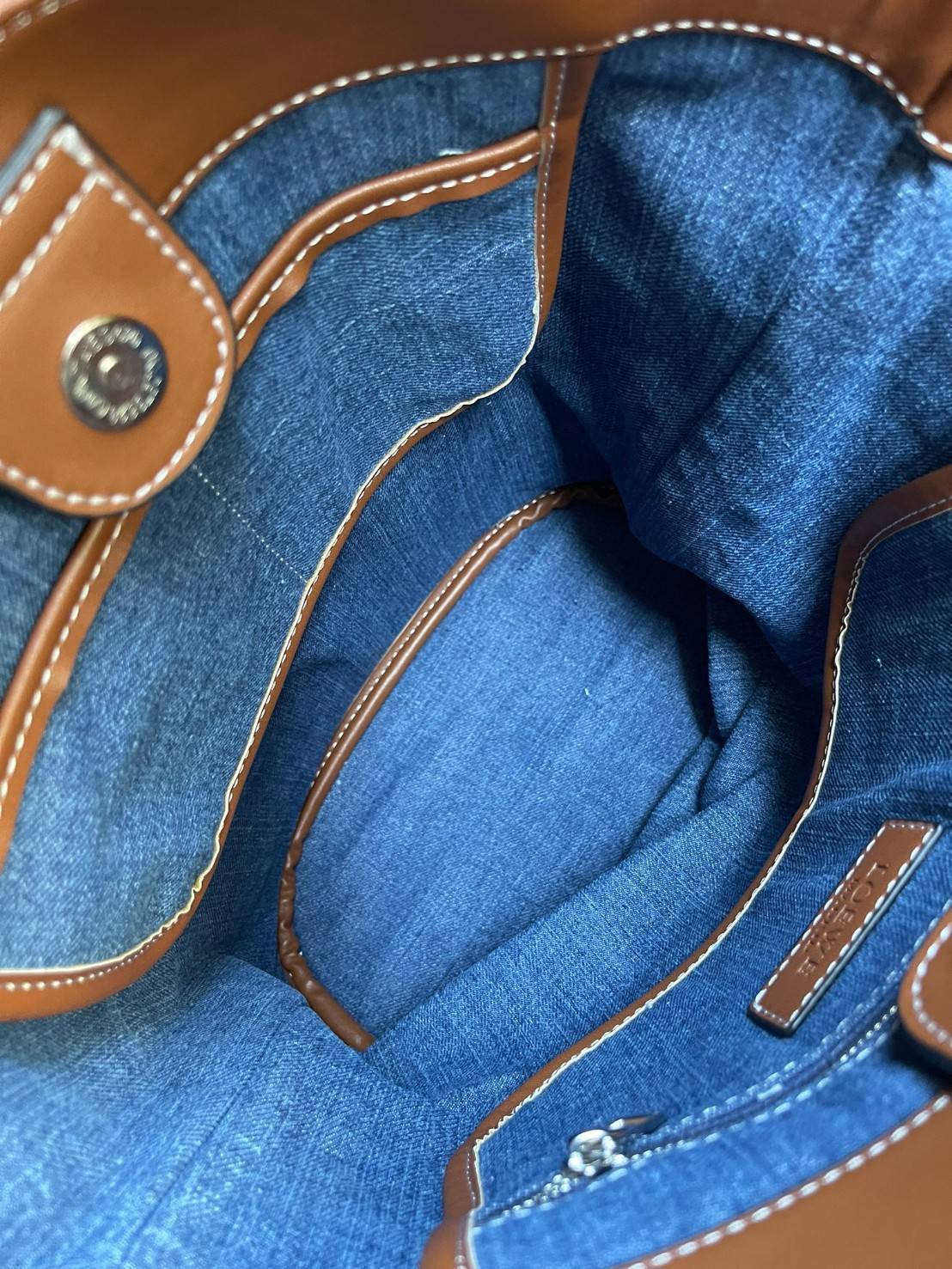 Loewe Denim Tote Bag กระเป๋าใบนี้มาในรูปแบบกระเป๋าทรงโท้ทที่สามารถเลือกใช้งานได้ทั้งแบบคล้องบ่าและแบบ Crossbody ดีไซน์เรียบง่ายไม่ซับซ้อน กระดุมแม่เหล็กเปิด-ปิดกระเป๋า มีช่องซิปเล็กด้านใน สามารถจุของได้เยอะ สำหรับสาวเซอร์ที่ชื่นชอบสไตล์การแต่งตัวอันเป็นเอ