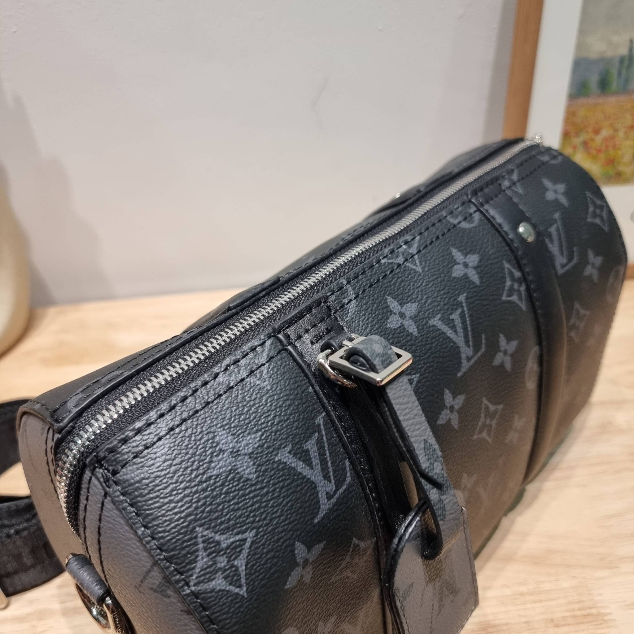 LV CITY KEEPALL Monogram Eclipse Bag กระเป๋าสะพายทรงหมอนสุดคลาสสิค ด้วยดีเทลความเป็นเอกลักษณ์ เรียบหรูด้วยความโดดเด่นจากลวดลายโมโนแกรม ขนาดกำลังดี