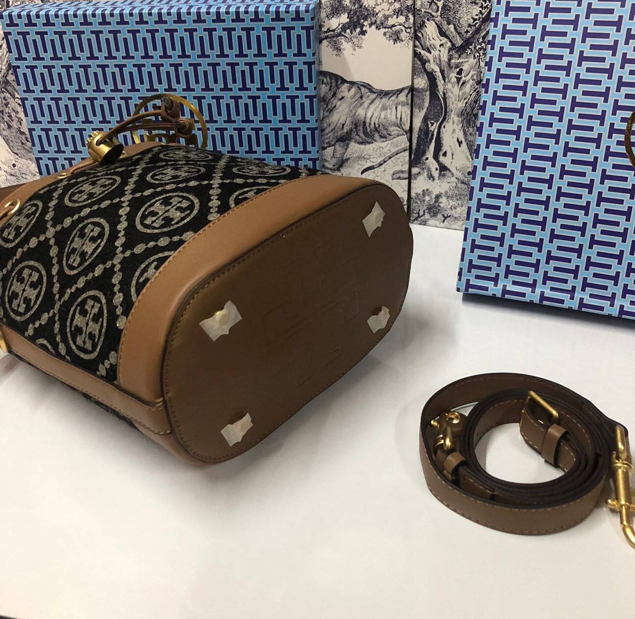 Medium : Tory Burch T Monogram Chenille Bucket Bag เปิดตัวอีกหนึ่งรุ่นกับกระเป๋าลาย T MONOGRAM รุ่นใหม่ล่าสุดจาก TORY BURCH พลาดไม่ได้กับโลโก้สุดคลาสสิก ลวดลาย T Monogram คือวัสดุ chenille หรือที่เรียกว่า ด้านไหมกำมะหยี่ มารังสรรค์ลงบนกระเป๋าBucketใบนี้ เ