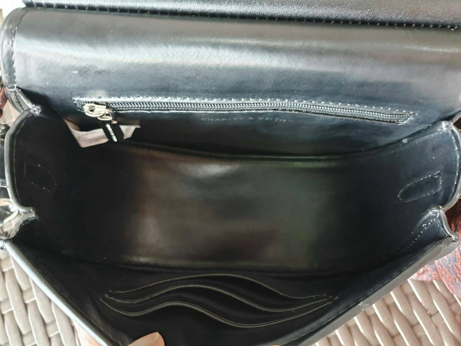 CHARLES & KEITH รุ่น LEATHER SATIN SCARF CROSSBODY BAG SL2-50150828 ราคาปกติช้อป ( ฿3,590.00 ) กระเป๋าถือ และ สะพาย ทรงโค้งมน หนังเรียบ ตั้งอยู่ทรง ด้านหน้าติดโลโก้แบรนด์ อะไหล่เงิน หูจับสายกระเป๋าร้อยเข้ากับห่วงเหล็กกลมๆ ด้วยผ้าลายสวยงามผูกเป็นโบว์เก๋ๆ ถ