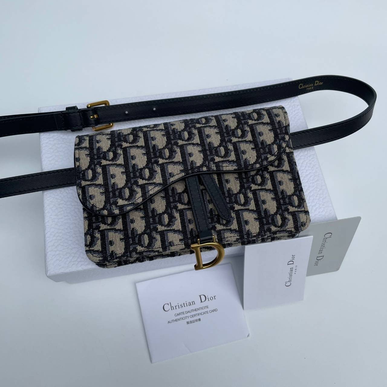 หนังแท้ DIOR SADDLE BELT POUCH Blue Dior Oblique Jacquard กระเป๋าคาดคาอก/คาดเอว เป็นทางเลือกที่ทันสมัยสำหรับกระเป๋าแบบคลาสสิก ตัดเย็บจากผ้าแจ็คการ์ด Dior Oblique โทนสี Navy Blue เข็มขัดถอดออกได้จะช่วยเสริมลุคให้ทุกชุด กระเป๋าคาดเอวจะสะพายไหล่ สะพายข้าง หร