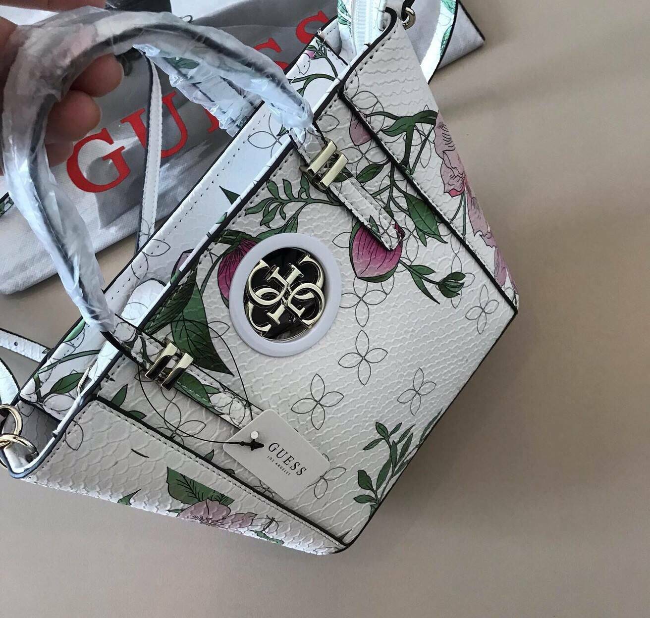 GUESS MINI CROSS BODY BAG กระเป๋าถือหรือสะพายรุ่นฮิตจาก GUESS FACTORY วัสดุ Saffiano PVC คุณภาพดี นิ่ม น้ำหนักเบา ด้านหน้าประดับด้วยโลโก้แบรนด์สุดหรู เปิดปิดกระเป๋าด้วยซิปสะดวกใช้ ด้านในโล่งกว้าง ซับในลายแบรนด์ สายสะพายยาวปรับได้ฟรีไซร์ ยาวสุด57cm. หูหิ้ว