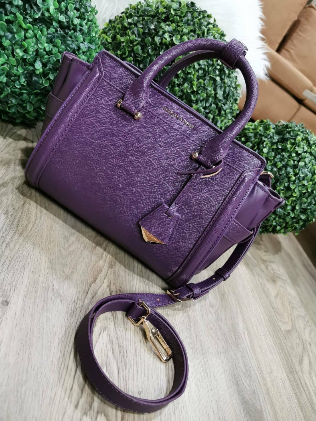 CHARLES & KEITH SAFFIANO TRAPEZE BAG กระเป๋าถือหรือสะพายรุ่นยอดนิยมดีไซน์สวยหรูวัสดุหนังคาเวียร์อยู่ทรง ด้านข้างเเต่งหนังช่องตัดดูมีดีเทล ด้านหน้ามีโลโก้ ด้านหลังมีช่องซิป เปิดปิดด้วยซิปหัวซิปแบรนด์ หูจับเเข็งแรง พับลงได้ พร้อมสายสะพายหนังปรับระดับได้ถอดไ