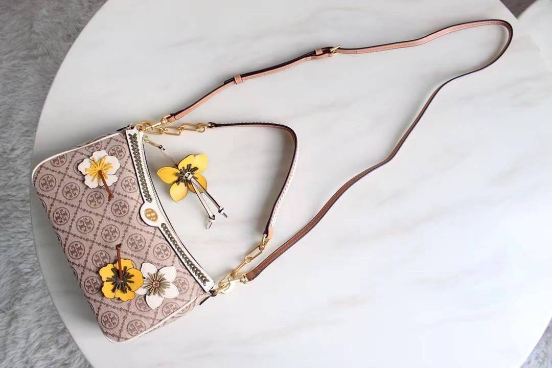 Tory Burch T Monogram Braided Floral Studio Shoulder Bag กระเป๋าถือหรือสะพายไหล่ลาย Monogramวัสดุผ้าJacquard+หนังแท้ ตัดเย็บอย่างปราณีต ผสานงานแกะสลักหนังสุดวิจิตร ประดับตกแต่งด้วยดอกไม้เพิ่มความหรู เป็นกระเป๋าดอกไม้ของฤดูกาลนี้ที่เพิ่มความซับซ้อนและแสนหว