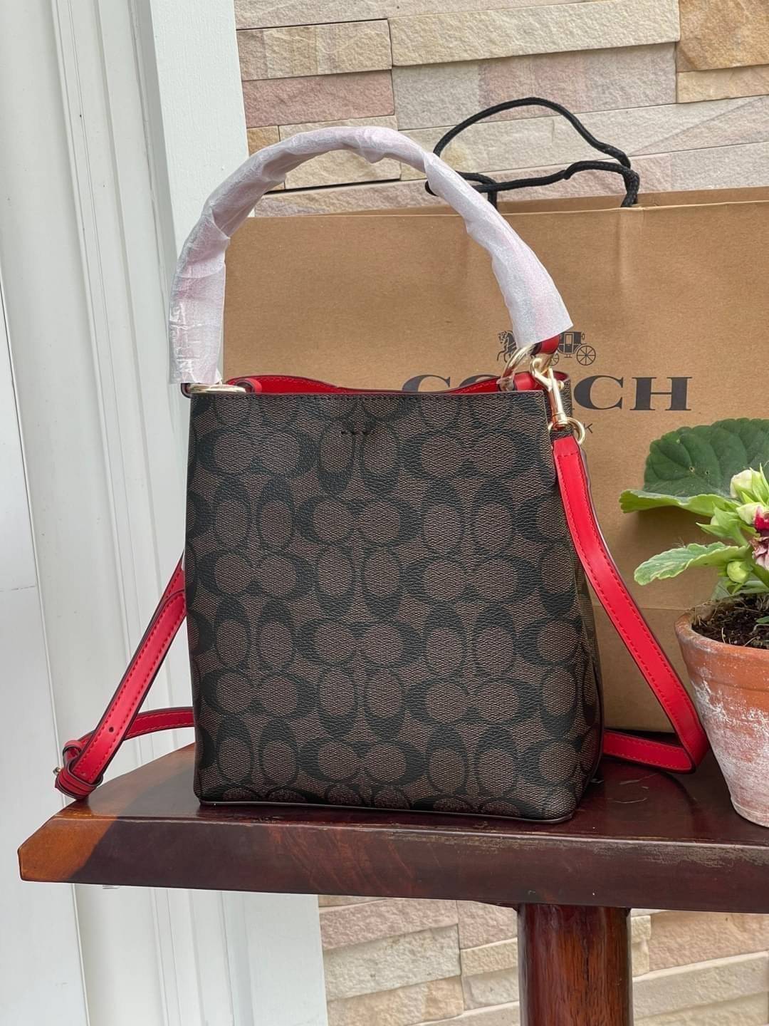 COACH SMALL TOWN BUCKET BAG IN SIGNATURE สำหรับสาวแฟชั่นที่ชอบรายละเอียดชิคๆ ดีไซน์สุดเก๋ แนะนำเลยสำหรับกระเป๋าทรงบักเก็ตใบนี้ เชื่อว่าสาว ๆ หลายคนชื่นชอบ เป็นไอเทมที่สามารถแมทช์ได้กับเสื้อหลากหลายสไตล์ บรรจุของได้เยอะโดยที่กระเป๋าไม่เสียทรง แบ่งช่องใช้งา