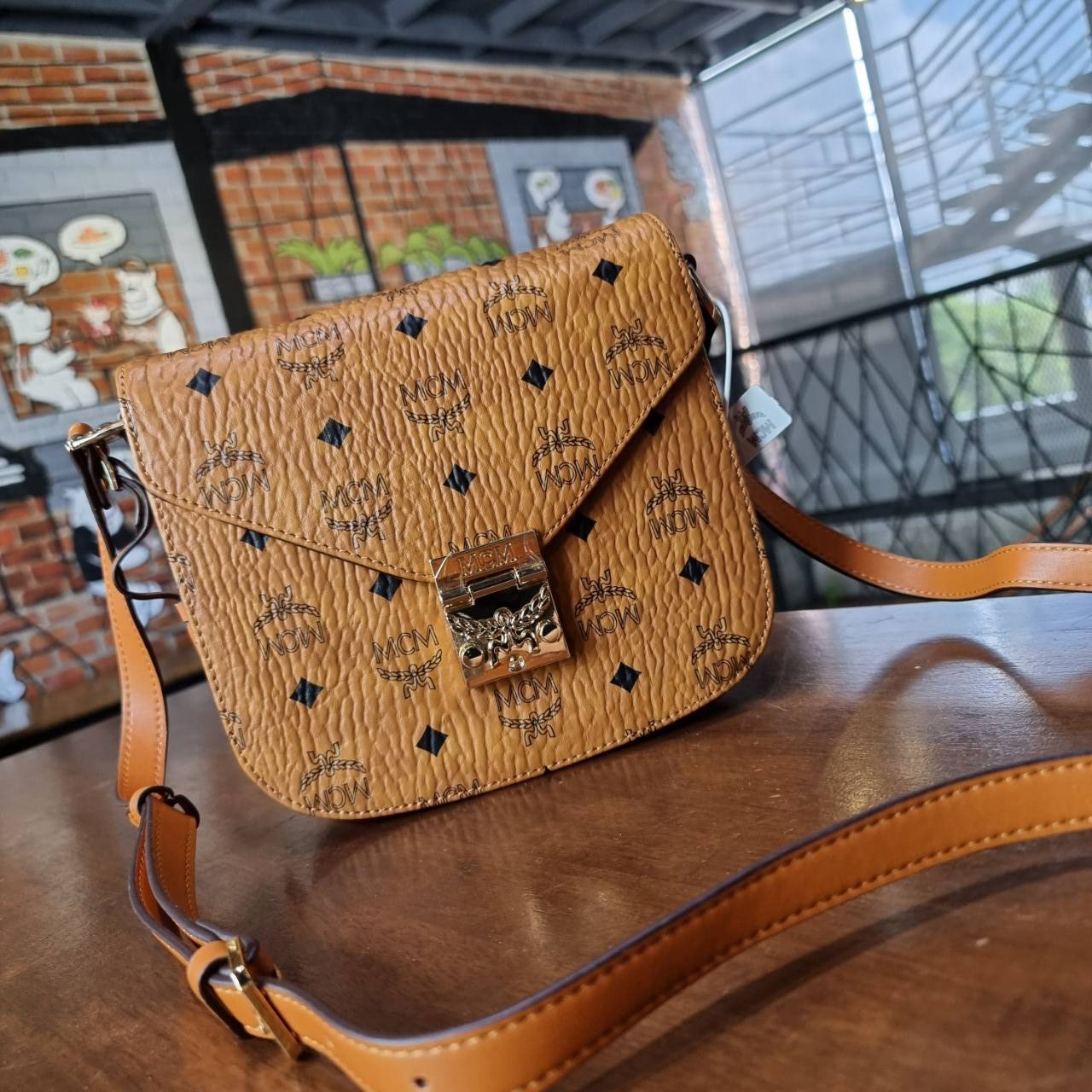 M.C.M PATRICIA SHOULDER BAG IN VISETOS กระเป๋าสะพายไหล่/ข้าง ดีไซน์ได้อย่างมีสไตล์ ดูมีสเน่ห์ด้วยทรงกระเป๋าที่โค้งบริเวณฐาน ให้ความรู้สึกนุ่มนวลมากขึ้น ใบนี้แมทช์ได้กับทุกลุค เท่ๆ casual หรูหรา หวานๆ ก็ทำให้โดดเด่นได้ด้วยไอเท็มนี้ วัสดุหนังแคนวาสคุณภาพดี 