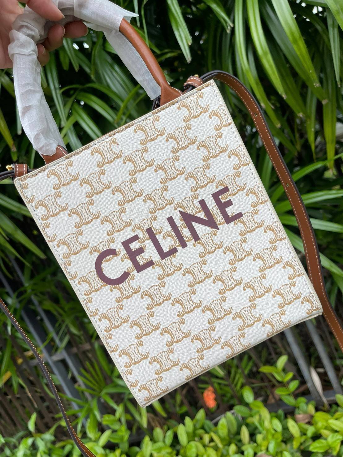 CELINE MINI VERTICAL CABAS IN TRIOMPHE CANVAS มีโลโก้ CELINE สกรีนอยู่ตรงกลาง ถือเป็นกระเป๋า Tote ที่ทำจากแคนวาสที่น่าสนใจมาก ๆ อีกรุ่นหนึ่ง และเป็นรุ่นที่ได้รับคำชื่นชมจากแฟชั่นกูรูทั้งหลายอีกด้วย หากใครที่อยากเป็นเจ้าของกระเป๋า Tote จาก CELINE สักใบ รุ่