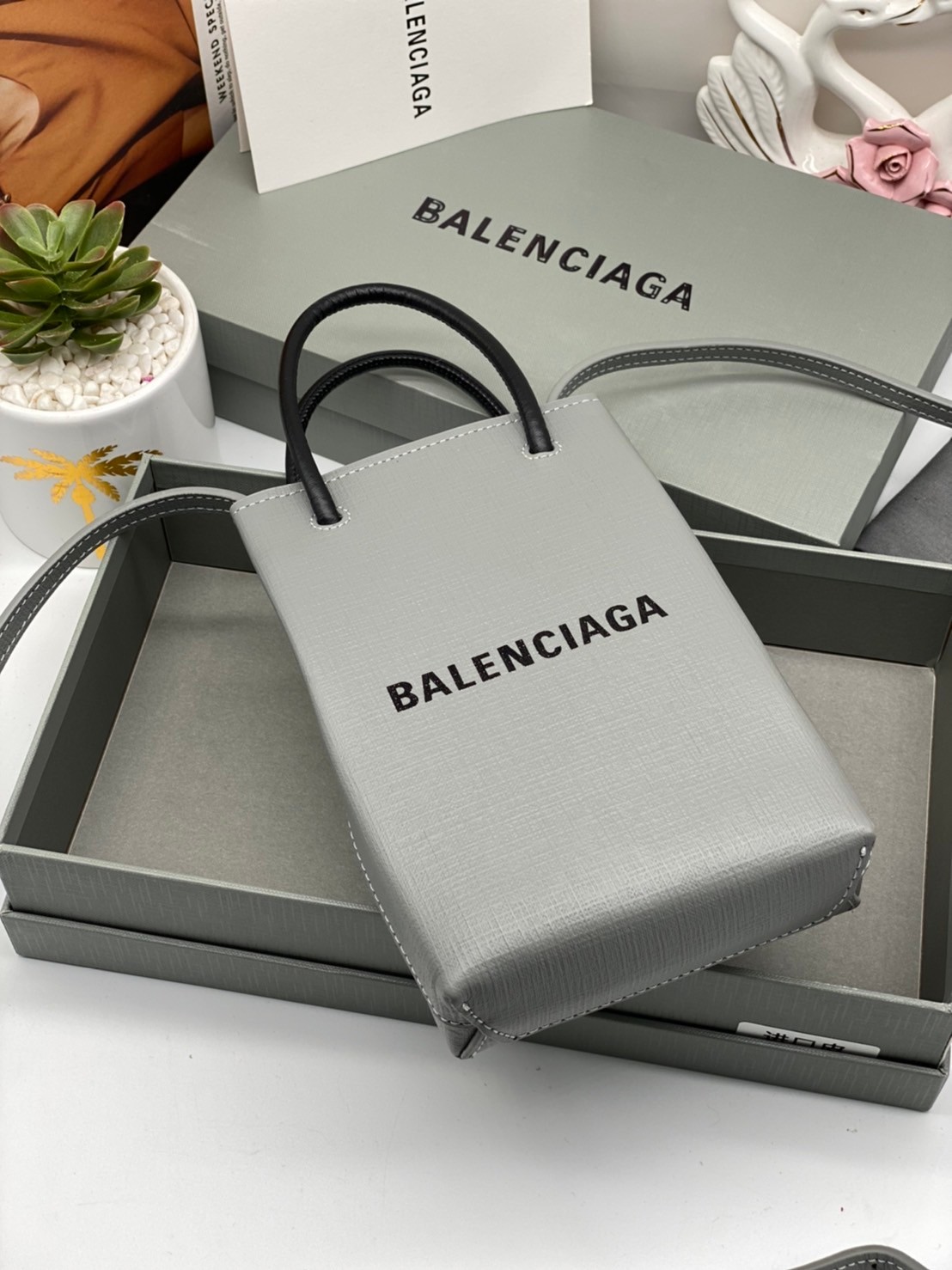 หนังแท้ BALENCIAGA Shopping Phone Pouch leather tote พกกระเป๋าช้อปปิ้งขนาดมินิ ไปทุกที่ในฤดูกาลนี้ ดีไซน์ที่ใช้ได้ทุกวันตั้งแต่หนังแบบมีเท็กซ์เจอร์ ภาพสินค้าถ่ายจากงานขายจริง ใช้งานต่างประเทศได้