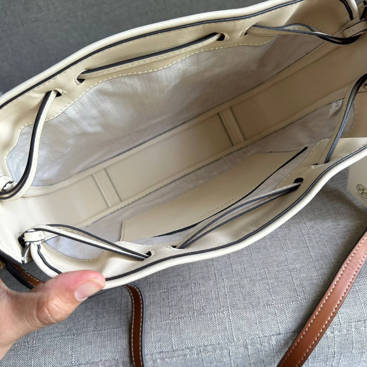 TORY BURCH T Monogram Straw Bell Bag กระเป๋าสะพายข้างรุ่นคลาสสิกที่ได้แรงบันดาลใจจากการควิลท์แบบดั้งเดิมของเพนซิลเวเนีย คอลเลกชันบ่งบอกถึงความมีสไตล์เหนือกาลเวลา รูปทรงเรียวโดดเด่น ปักทอลายแบรนด์อย่างสวยงาม เปิด ปิดด้วยเชือกรูด ด้านในช่องโล่งกว้าง ซับในผ้