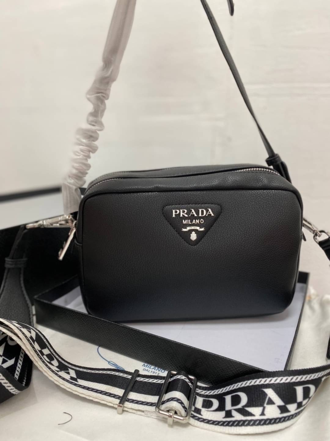 PRADA CAMERA LEATHER BAG with shoulder strap / PRADA MESSENGER BAG BLACK กระเป๋าสะพายหนัง รุ่น Unisex ใช้ได้ทั้งชายหญิง ขนาดกำลังดี ดีไซน์เรียบ แต่หรูหรา พร้อมสายสะพาย 2 เส้น ปรับระดับได้ สามารถสะพายไหล่ และครอสบอดี้