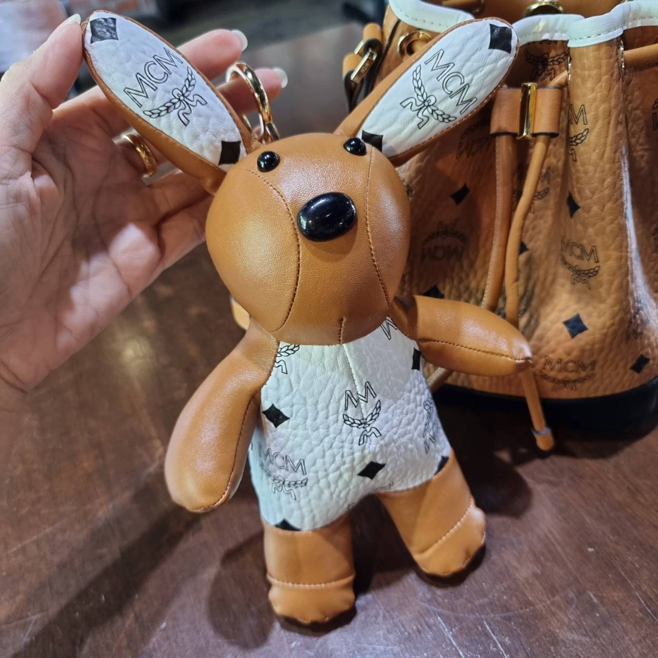 M.C.M ZOO RABBIT DRAWSTRING BAG IN VISETOS LEATHER MIX คอลเลคชั่นซูมาใหม่ ฮิตหนักมากที่เกาหลีและญี่ปุ่น ไอเท็มสุดคิ้วท์ น้องกระะต่ายโดดเด่น กระเป๋าสะพายทรง bucket ไซส์เล็กขนาดน่ารักน่าใช้ แฟชั่นสไตล์มากใบนี้ ดีไซน์น้องกระต่ายแอบในกระเป๋า และสามารถนำออกมาห