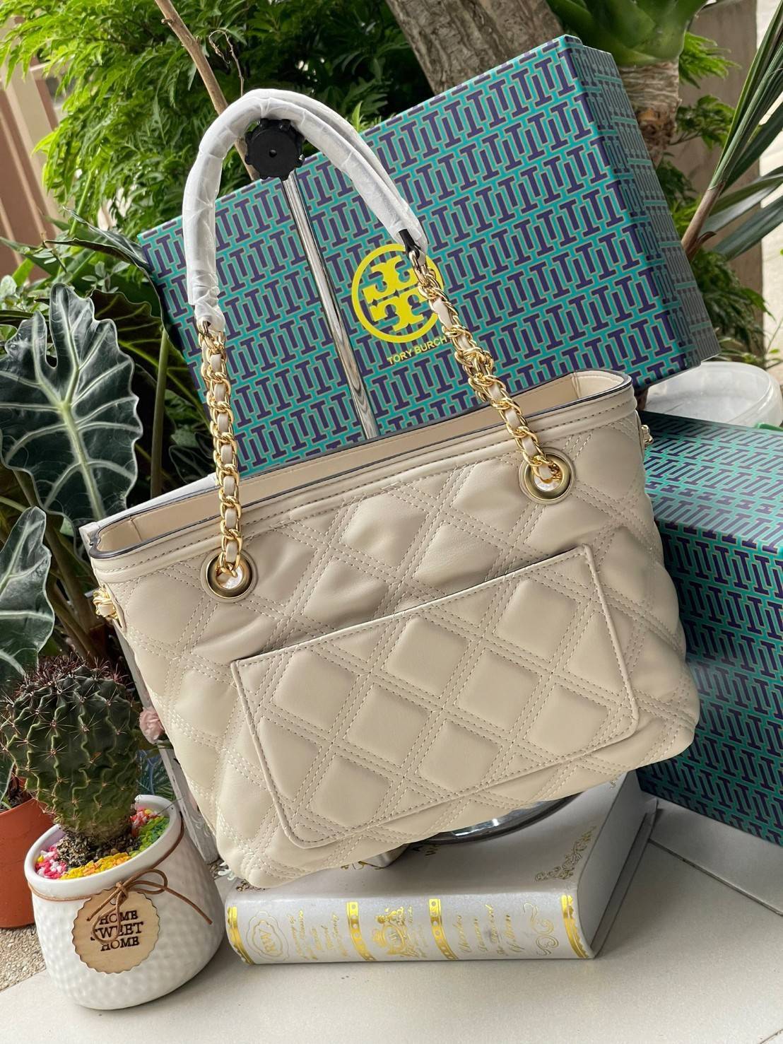 Tory Burch Fleming Soft Small Tote Bag เป็นกระเป๋าสะพายไหล่น่ารัก ๆ สักใบที่มีดีไซน์โดดเด่น สะดุดตา ใน Collection เรียกได้ว่าขายดีอันดับต้น ๆ ของแบรนด์ ใช้ได้ในลุคช์ทางการและกึ่งทางการ ดีเทลการตัดเย็บพิมพ์ลายนูนคู่กับแพทเทิร์นสี่เหลี่ยมทรงเพชร ที่ช่วยเพิ่