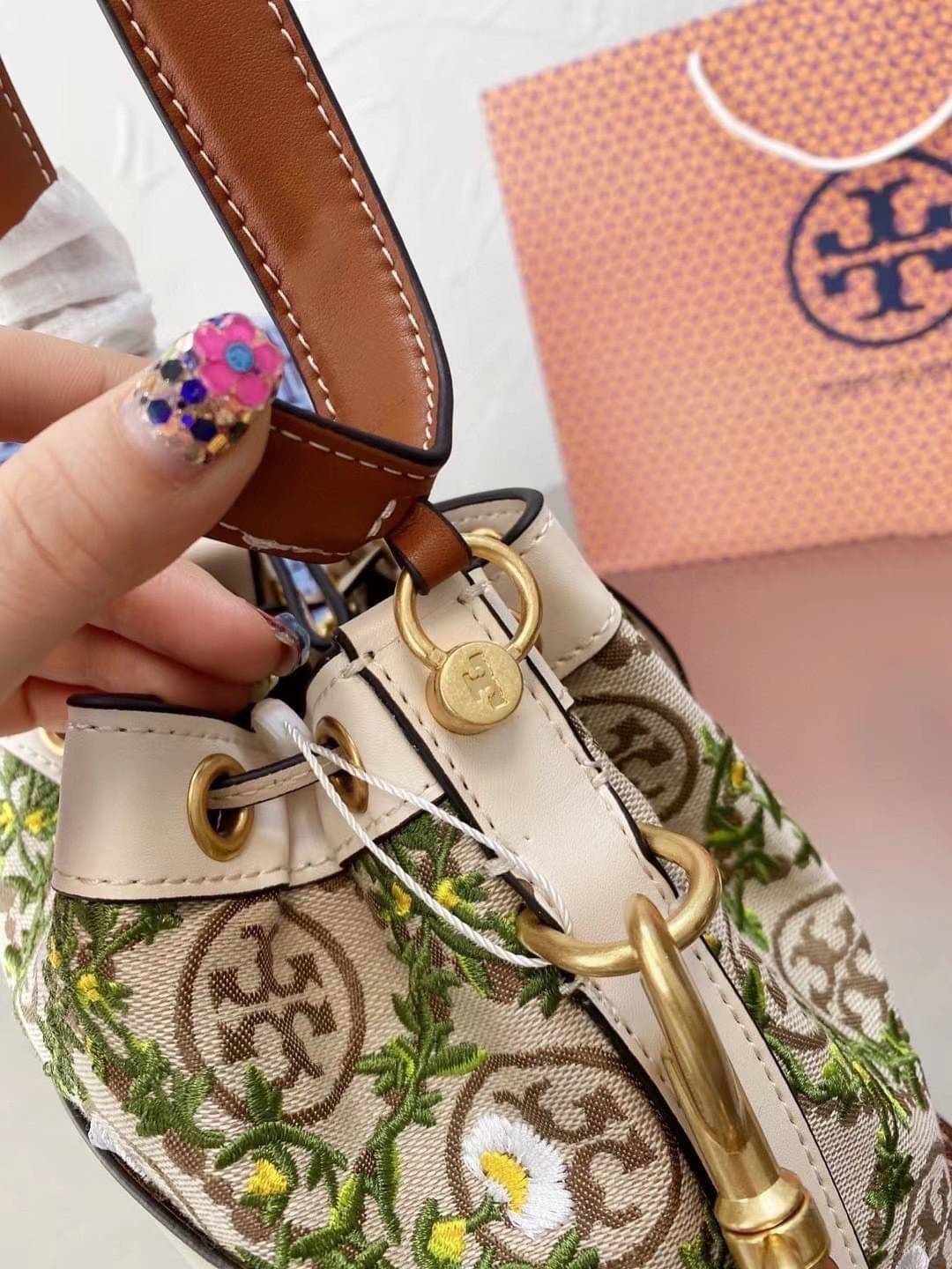 TORY BURCH T MONOGRAM JACQUARD EMBROIDERED BUCKET BAG ครั้งแรกกับโมโนแกรม ที่ได้รับแรงบันดาลใจมาจากโลโก้สุดคลาสสิก กลับมาอีกครั้งในรูปแบบของ ลวดลาย T Monogram ที่ผสมผสานความร่วมสมัยเข้ากับความเป็นเอกลักษณ์ของแบรนด์เข้าไว้ด้วยกัน โดยเป็นการนำเอาลวดลาย T Mo