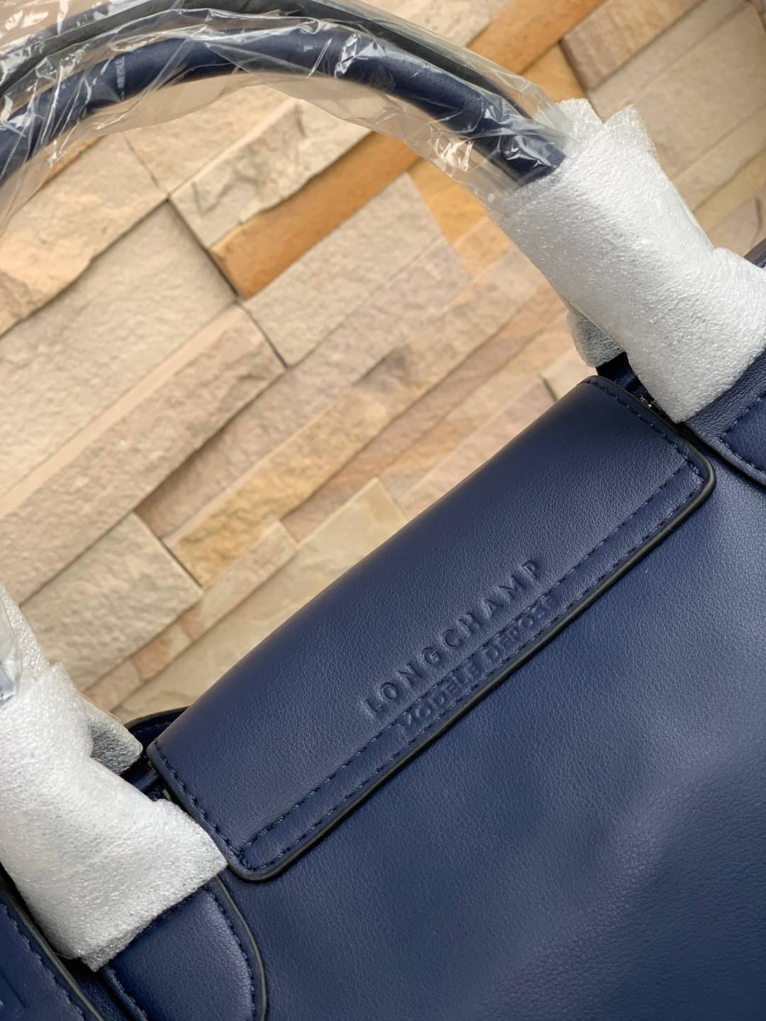 Longchamp LE PLIAGE CUIR TOP HANDLE BAG S เรียกว่าเป็นกระเป๋าอีกหนึ่งรุ่นที่ไม่ว่ายังไงก็ฮอตฮิตและติดเทรนด์ตลอดไม่เคยเปลี่ยนกับ ทรง Le Pliage Cuir หนึ่งในตระกูลกระเป๋าสุดไอคอนิกจากแบรนด์ เมื่อรุ่น Le Pliage Cuir ในรูปแบบของหนังแกะ Metis ได้ถือกำเนิดขึ้นใน