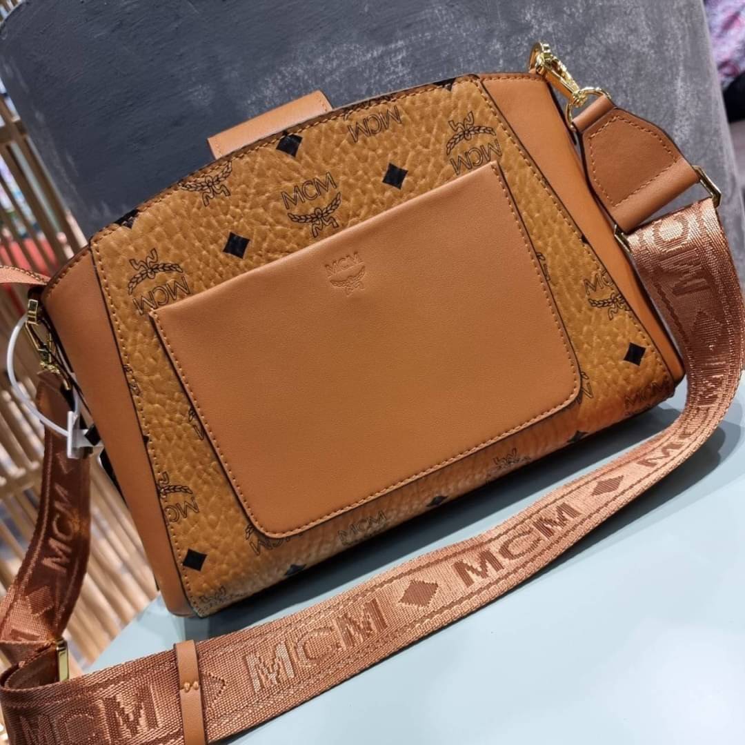 M.C.M ESSENTIAL VISETOS ORIGINAL SMALL CROSSBODY BAG กระเป๋าสะพายข้าง ขนาดกำลังดี สวยอยู่ทรง ดีไซน์เป็นเอกลักษณ์ วัสดุหนังแคนวาสสลับหนังแท้ พริ้นท์ลายเต็มใบ ดูหรูมาก!! เปิด-ปิดกระเป๋าด้วยสายคาดแม่เหล็ก และซิปรูดกันของหล่น มาพร้อมสายสะพาย crossbody ปั๊มลาย