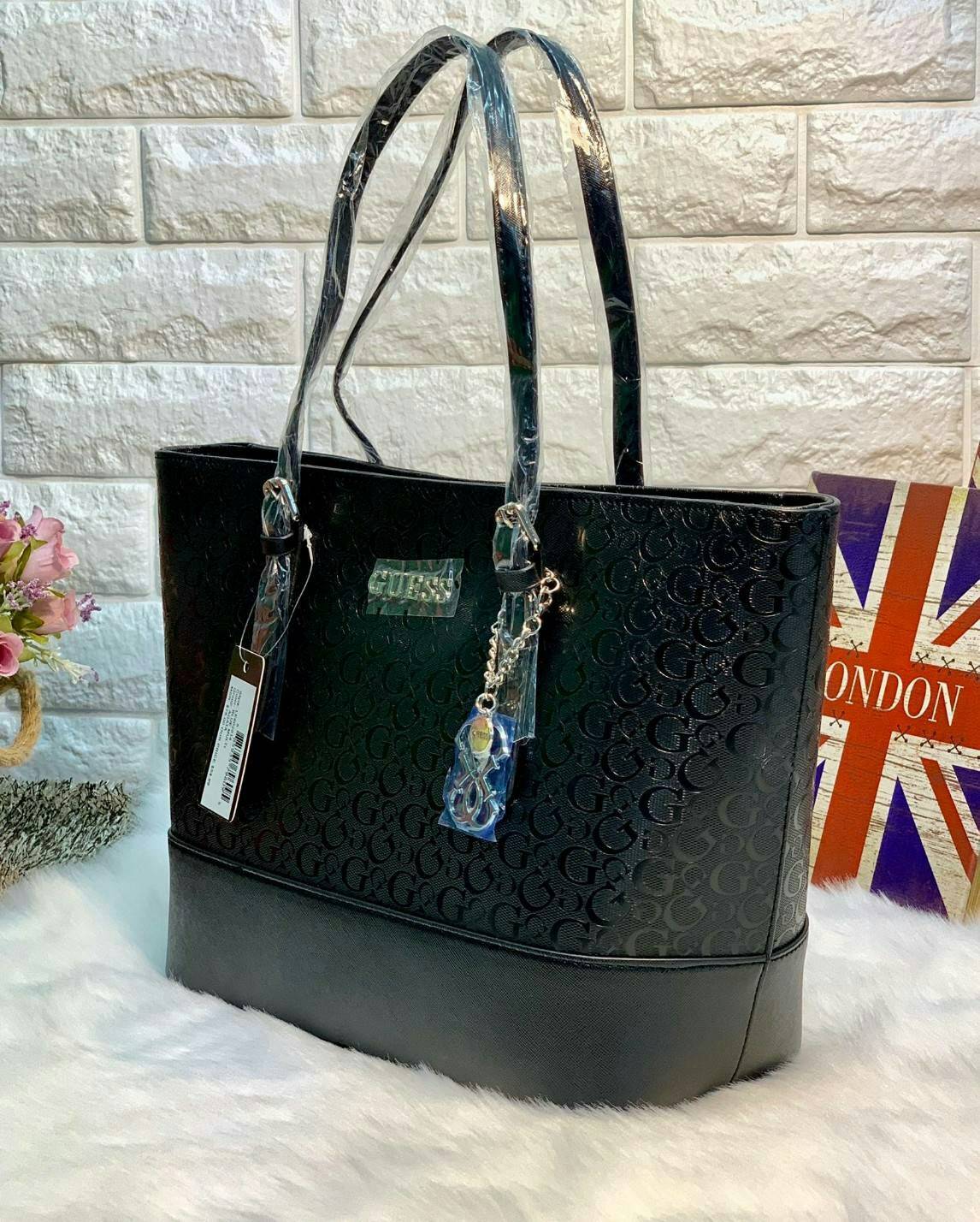 GUESS WOMEN LARGE TOTE BAG กระเป๋าถือ//สะพายไหล่ ทรง Tote ตัวกระเป๋าลายแบรนด์ทั้งใบ ผสมหนังซาฟเฟียโน่ตรงขอบล่างกระเป๋าค่ะ ด้านหน้าห้อยอะไหล่แบรนด์มาให้ เปิดปิดกระเป๋าแบบซิป ภายในโล่ง กว้าง ใส่ของได้จุค่ะ มีช่องซิปและช่องเล็กใส่ของจุกจิกนะค่ะ หูหิ้วสามารถป