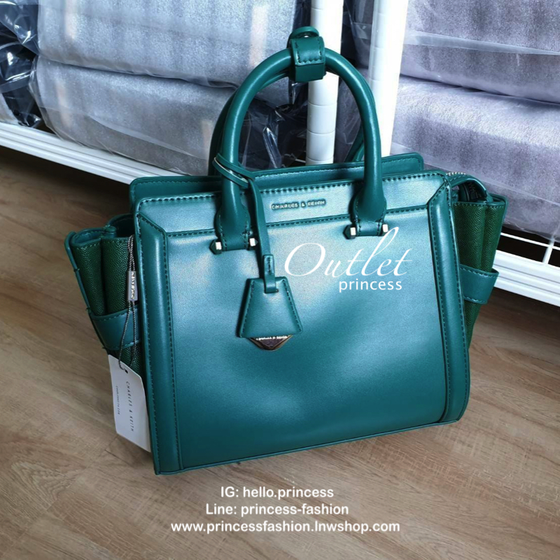 CHARLES & KEITH กระเป๋าถือ/สะพายข้าง ขนาดกลาง ด้านหน้าปั๊มโลโก้แบรนด์ ด้านหน้าเป็นหนังเรียบตัดกับด้านข้างเป็นหนังคาร์เวียร์ออกแบบมาให้เรียบหรู ด้านหลังมีซิป 1 ช่อง หูกระเป๋าสามารถพับลงได้ ส่วนด้านในกว้างมากค่ะ ออกแบบมาให้ใส่ของได้จุใจแบบไม่มีช่องแบ่ง มีช่