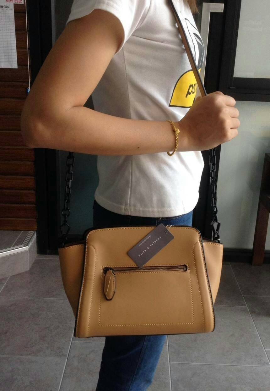 CHARLES & KEITH TRAPEZE CROSSBODY BAG กระเป๋าถือหรือสะพายดีไซน์ยอดนิยมหนังอยู่ทรงสวย ด้านหน้าสกรีนโลโก้ และมี 1 ช่องซิป เปิดปิดด้วยซิป ภายในมีช่องใส่ของ และช่องซิปเล็ก ใส่กระเป๋าสตางค์ใบยาว มือถือ ของใช้ได้เยอะ พร้อมสายสะพายยาวโซ่ต่อหนังปรับได้ถอดได้ มีหม