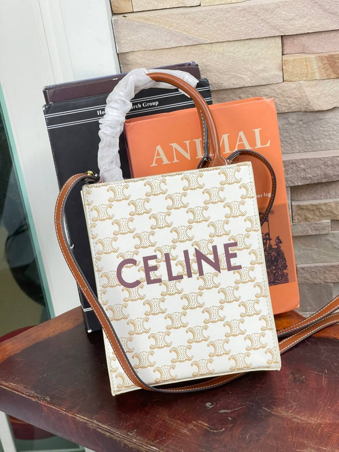 CELINE MINI VERTICAL CABAS IN TRIOMPHE CANVAS มีโลโก้ CELINE สกรีนอยู่ตรงกลาง ถือเป็นกระเป๋า Tote ที่ทำจากแคนวาสที่น่าสนใจมาก ๆ อีกรุ่นหนึ่ง และเป็นรุ่นที่ได้รับคำชื่นชมจากแฟชั่นกูรูทั้งหลายอีกด้วย หากใครที่อยากเป็นเจ้าของกระเป๋า Tote จาก CELINE สักใบ รุ่
