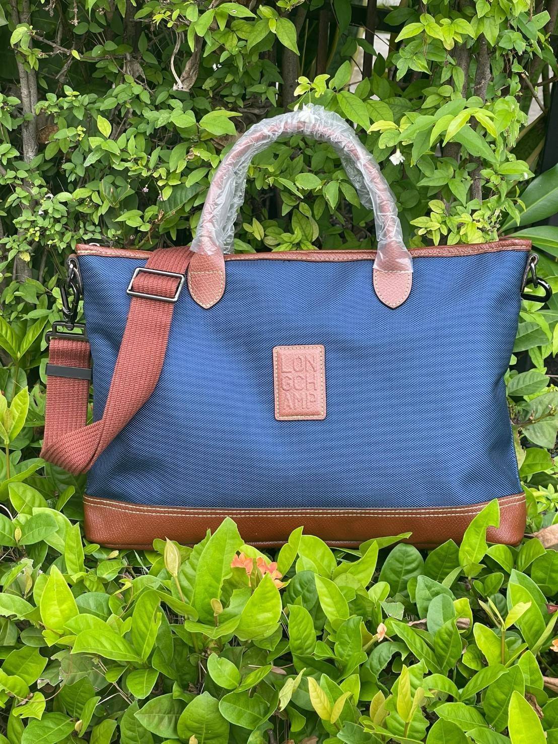 LONGCHAMP BOXFORD TRAVEL BAG M กระเป๋าเดินทางขนาดกลาง มาพร้อมสายสะพายที่สามารถถอดได้ ให้คุณเลือกสะพายไหล่หรือถือได้ มีซิปรูดเปิดปิดกระเป๋าที่ให้คุณมั่นใจได้ว่าคุณจัดเก็บไอเท็มของคุณได้อย่างมิดชิด บ็อคฟอร์ด (BOXFORD) สะท้อนความเป็นเอกลักษณ์ของแบรนด์ที่เปี่