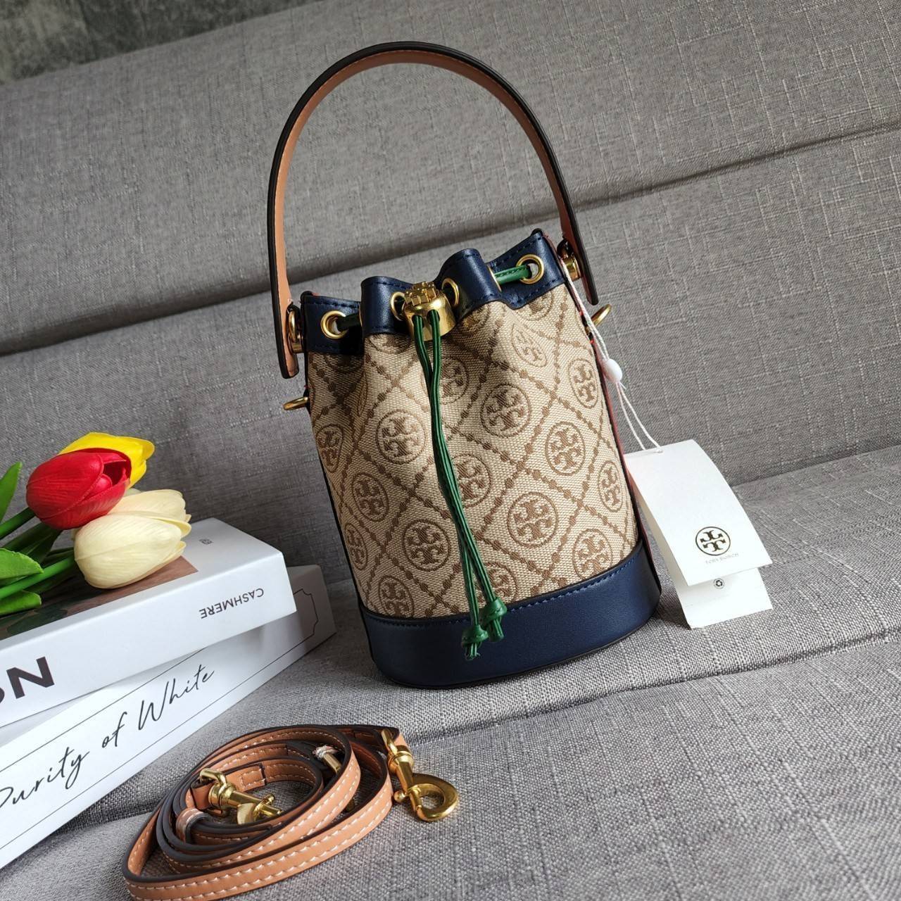 TORY BURCH T MONOGRAM COLORBlOCK JACQUARD MINI BUCKET BAG คอลเลคชั่นใหม่ล่าสุด ครอบครองก่อนใคร รุ่นบัคเก็ตทรงจีบ วัสดุ jacquard สลับหนังแท้ ตัดขอบข้างสีแดงทำให้ดูโดดเด่น หูจับหนังแท้ เปิด ปิด แบบหูรูด ภายในช่องโล่งกว้าง มาพร้อมสายสะพายข้างหนังแท้ ปรับระดั