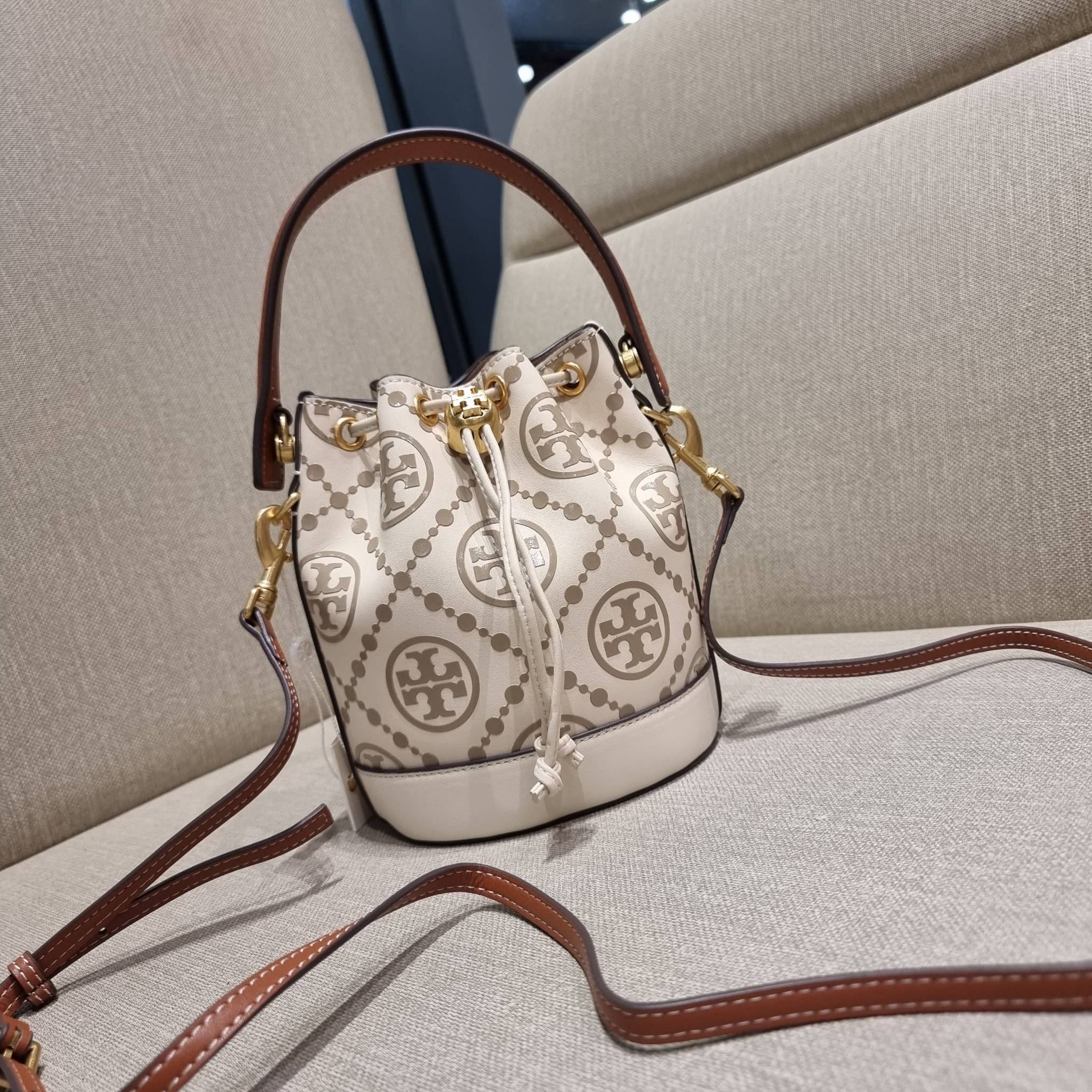 TORY BURCH T MONOGRAM EMBOSSED MINI BUCKET BAG คอลเลคชั่นใหม่ กับกระเป๋าบัคเก็ตทรงยอดนิยม ในไซส์มินิ ดีไซน์ใหม่ล่าสุด สวยลูกคุณหนู หรูหรา!! ด้วยดีเทลผิวลายนูนลวดลายเอกลักษณ์ วัสดุหนังแท้ ปากกระเป๋ารูดเปิด-ปิดได้ มีหูจับในตัว สะดวกใช้ไปอีก และมีสายสะพายข้า