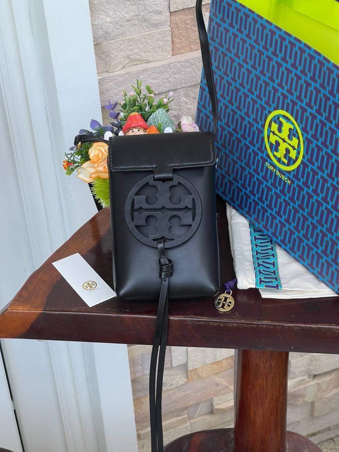 TORY BURCH MILLER METAL PHONE CROSSBODY อีกหนึ่งกระเป๋าใส่มือถือรุ่นฮิตที่เชื่อว่าหลาย ๆ คนต้องเคยเห็นผ่าน ๆ ตามาอย่างแน่นอน กับแบรนด์ Tory Burch ดีไซน์กระเป๋าทรงฝาพับแม่เหล็กใช้งานง่าย มาพร้อมดีเทล Logo สีเดียวกับเฉดสีของกระเป๋า แต่ยังมีความน่ารักด้วยทรง