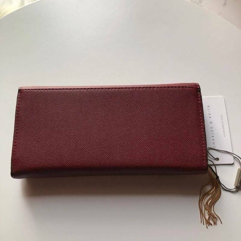 CHARLES & KEITH LONG WALLET กระเป๋าสตางค์ใบยาวแบบ 2 พับ หนังคาเวียร์ อะไหล่สีทอง และพู่สวยหรูมากค่ะด้านหน้าปั้มโลโก้แบรนด์ เปิดปิดด้วยฝาปิด ภายในมี1ช่องซิปแชะช่องเก็บบัตรหลายช่องใช้งานใส่ช่องใส่ธนบัตร แยกเป็นสัดส่วน ใบนี้สุดคุ้มเลยค่า