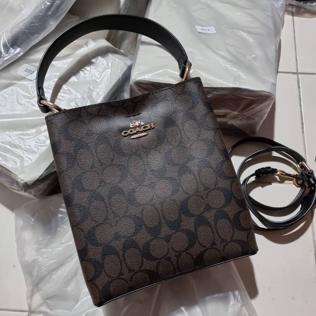 COACH 2312 SMALL TOWN BUCKET BAG IN SIGNATURE CANVAS รุ่นยอดนิยมใบเล็กมาครบสีแล้วจ้า กระเป๋าทรงบัคเก็ต สีผู้ดี๊ผู้ดี ตัวกระเป๋าดีไซน์คลาสสิคลายซี ดูโดดเด่น วัสดุหนังแคนวาสเคลือบลาย สวยคมทุกมุมจริงๆ!! เปิด-ปิดด้วยกระดุมแม่เหล็กทั้ง 2 ฝั่ง ภายในเป็นช่องโล่ง
