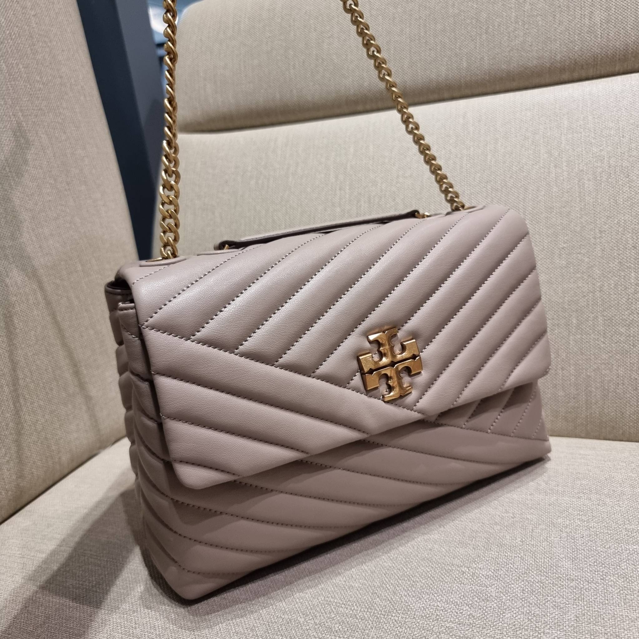 TORY BURCH KIRA CHEVRON CONVERTIBLE SHOULDER BAG กระเป๋าสะพายรุ่นยอดฮิต ไซส์ใหญ่จัดเต็มให้เน้นๆ ใช้ยังไงก็ดูหรู ดีไซน์เฉพาะตัว วัสดุหนังแกะ สัมผัสนิ่ม เปิด-ปิดด้วยกระดุมแม่เหล็ก ภายในเป็นช่องโล่ง แบ่งสัดส่วนไว้ดีมากๆ ใส่กระเป๋าสตางค์ มือถือ เครื่องสำอางค์