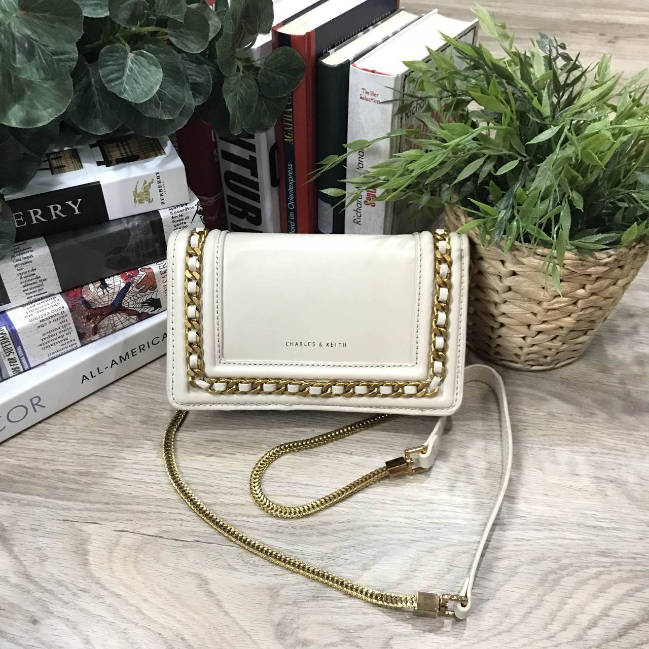 NEW ARRIVAL! CHARLES & KEITH CHAIN DETAIL CROSSBODY BAG กระเป๋าสะพายทรงสี่เหลี่ยมรุ่นชนช็อปขนาดกำลังดีวัสดุหนังนิ่มเรียบประดับด้วยโซ่ด้านหน้าดูมีดีเทล เปิดปิดด้วยกระดุมแม่เหล็ก ภายในมีช่องใส่บัตรและช่องซิป มาพร้อมสายโซ่ต่อหนังถอดถือเป็นคลัชได้ ภาพถ่ายสินค