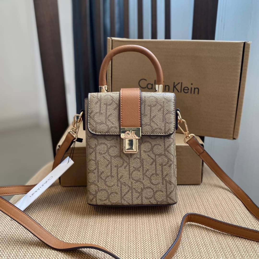 CALVIN KLEIN JEANS crossbody bag กระเป๋าถือหรือสะพาย ลายซิกเนเจอร์แบรนด์ทั้งใบ มีหูจับสำหรับถือ เปิด-ปิดกระเป๋าด้วยกระดุมแม่เหล็ก ด้านในโล่งกว้างมีช่องเล็กและช่องซิปสำหรับใส่ของจุกจิก ซับในลายแบรนด์อย่างดี มาพร้อมสายสะพายยาวปรับระดับได้ สามารถใช้ได้หลากหล